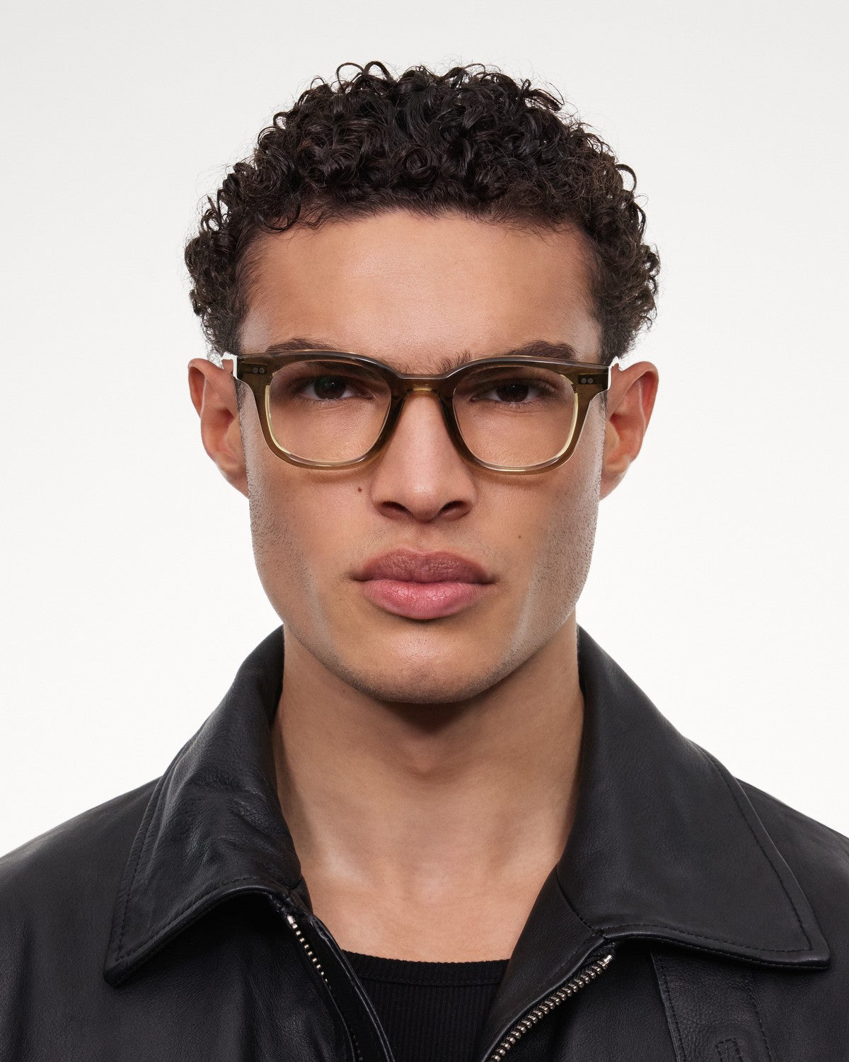 Model wearing CHIMI 02 Core Green Clear eyeglasses with a black leather jacket.