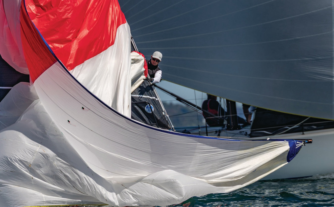 Sailboat with a large red and white sail on a clear day