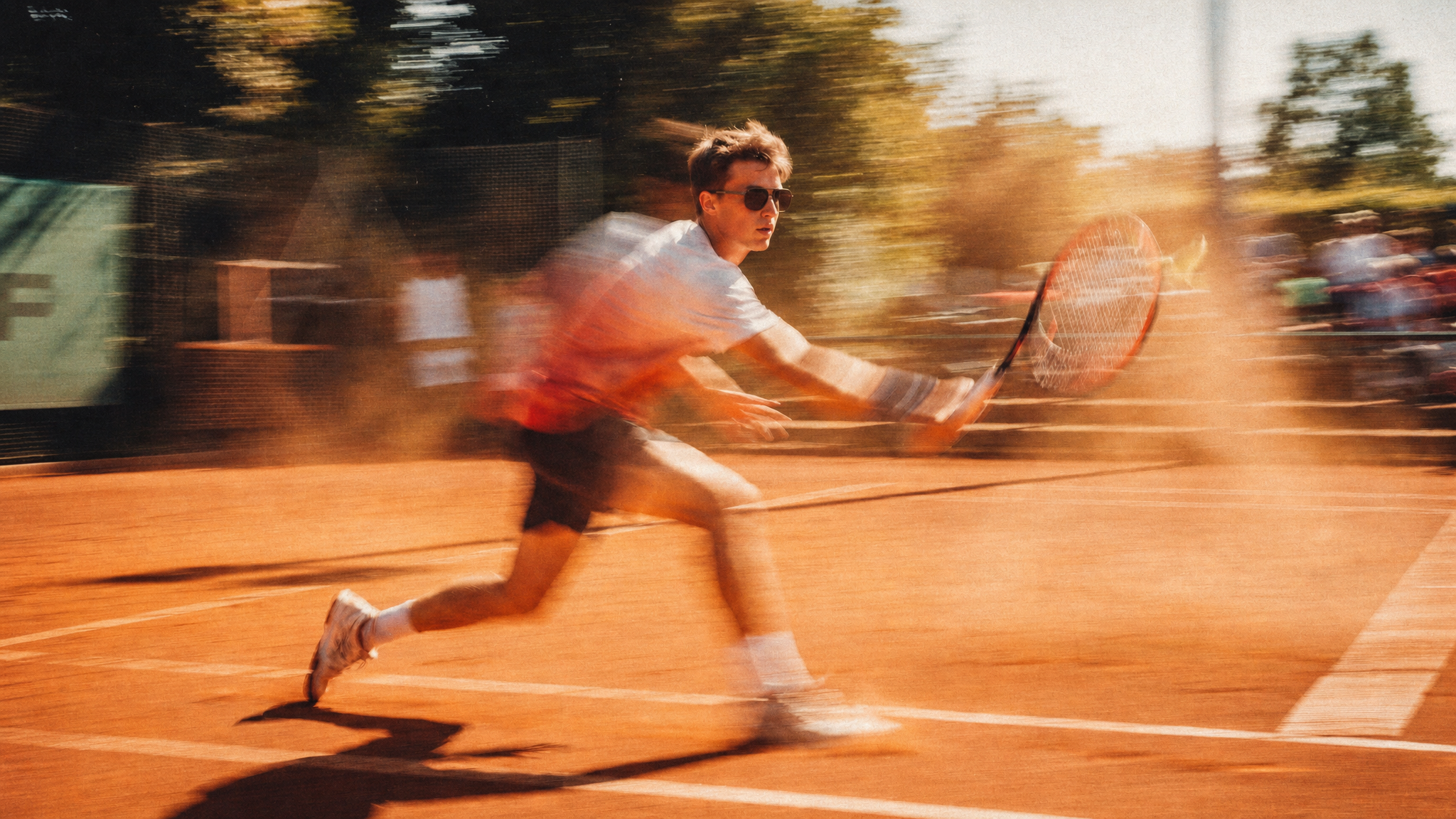 Tennis player in action on a clay court with a blurred background