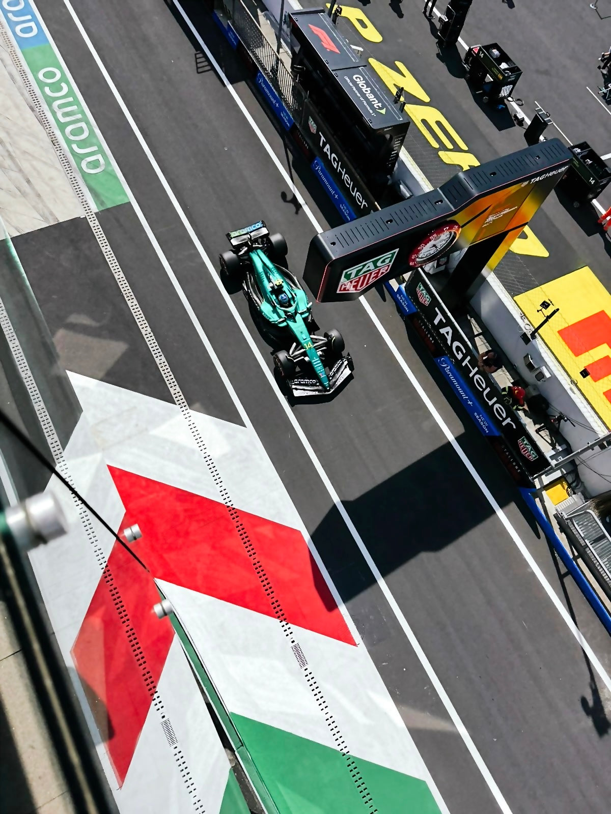 Formula 1 car at a pit stop on a racetrack with branding visible