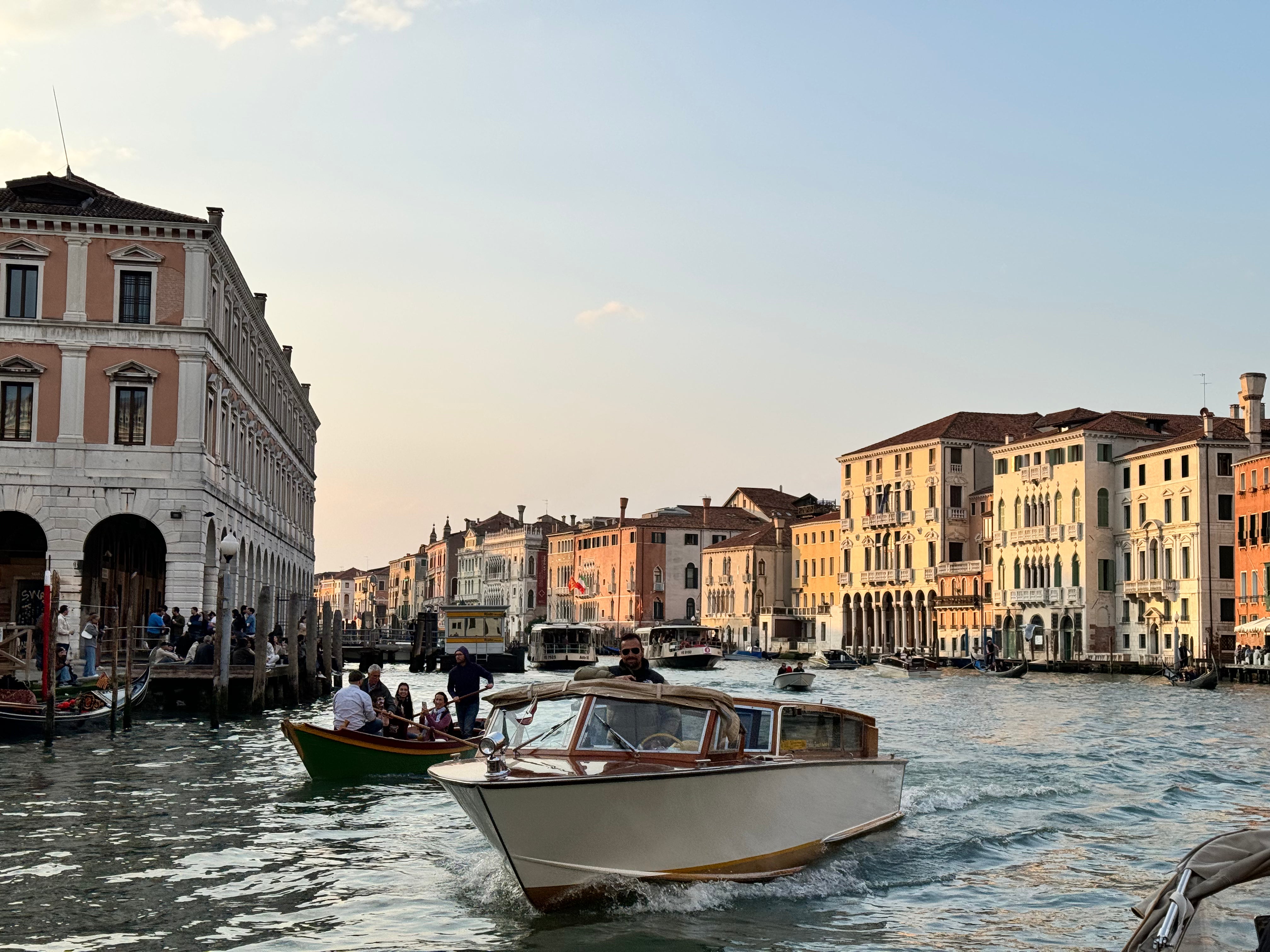 Boats on a canal with historic buildings in the background in Venice