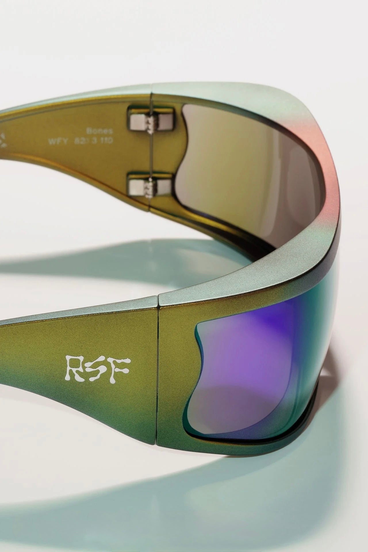 Close-up of a pair of sunglasses with a visible brand logo on a light background