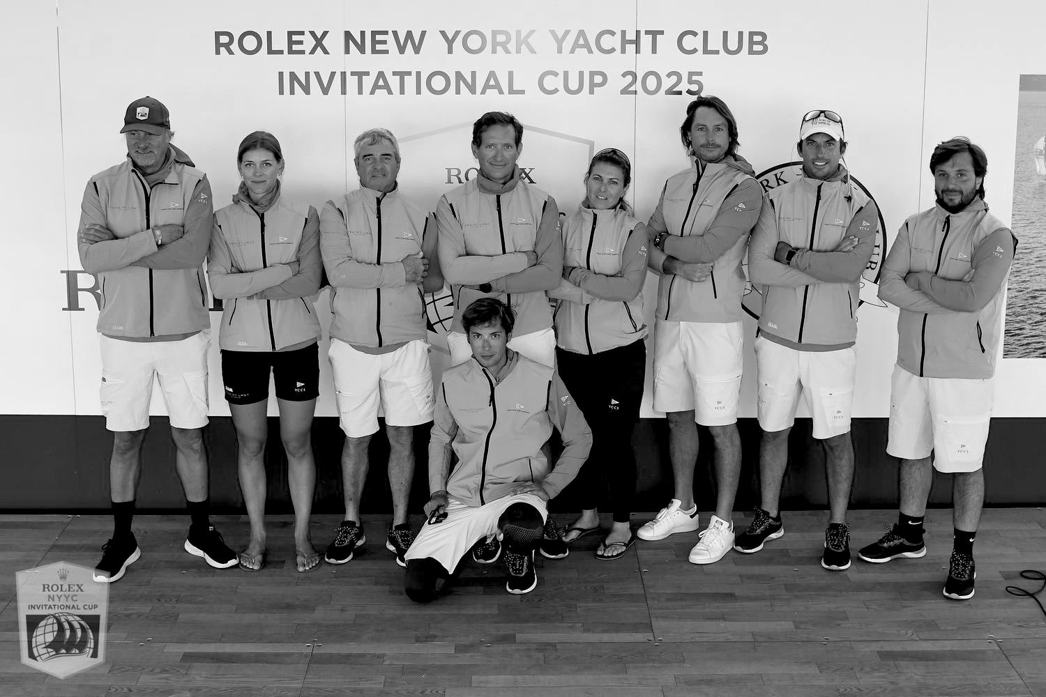 Group of people posing together with a Rolex logo in the background