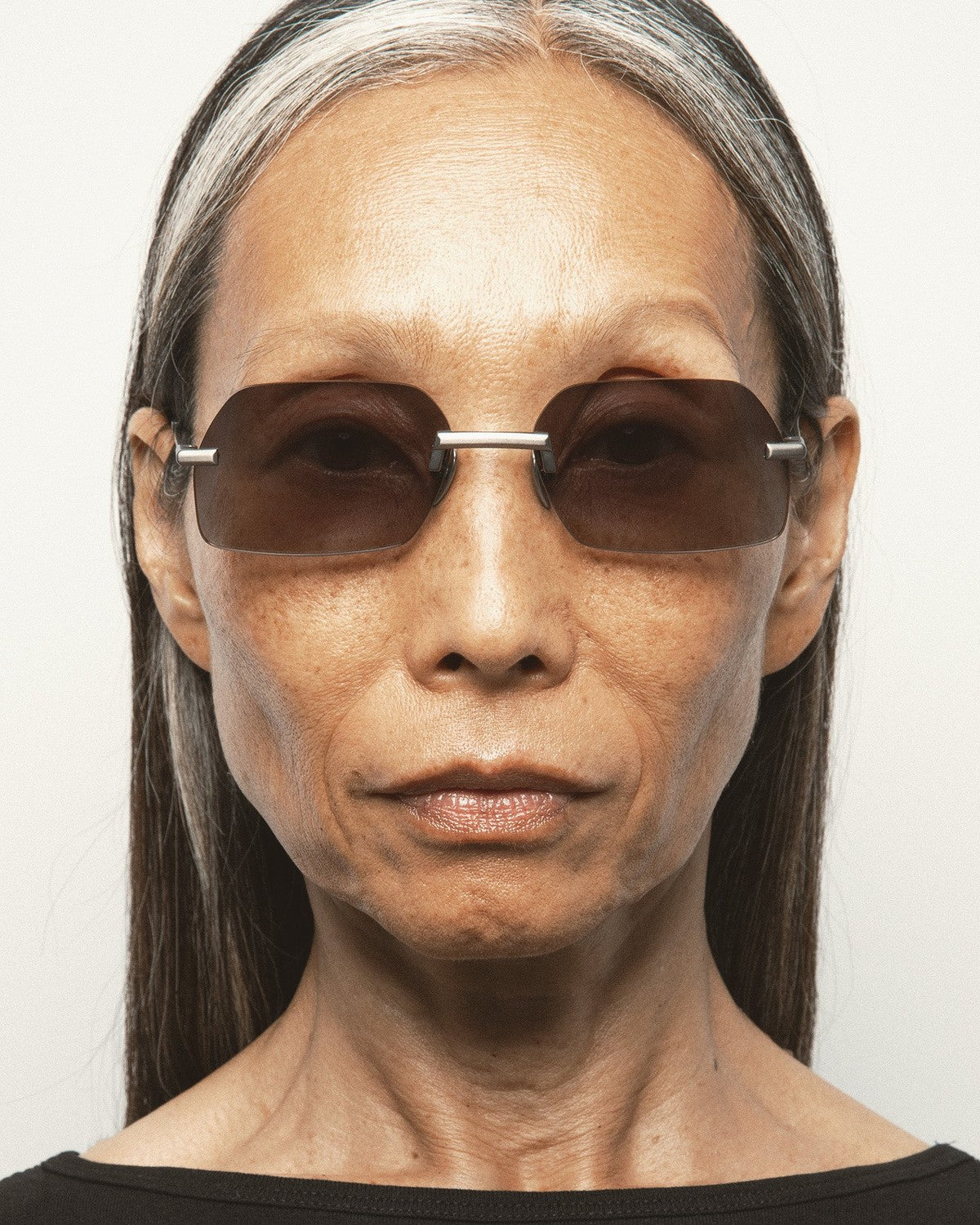 Try-on view of KALEOS Anselm Gun Matte Black Gradient sunglasses on a model.