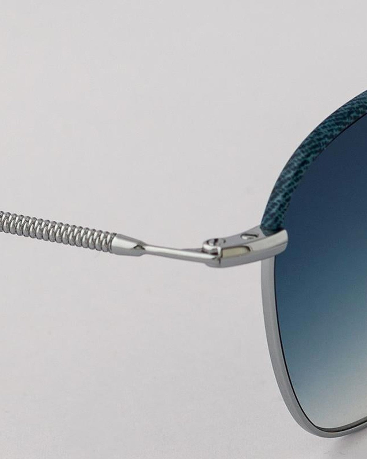 Close-up of the coiled wire temple hinge on EYEPETIZER ATACAMA C.1-R-26 sunglasses.