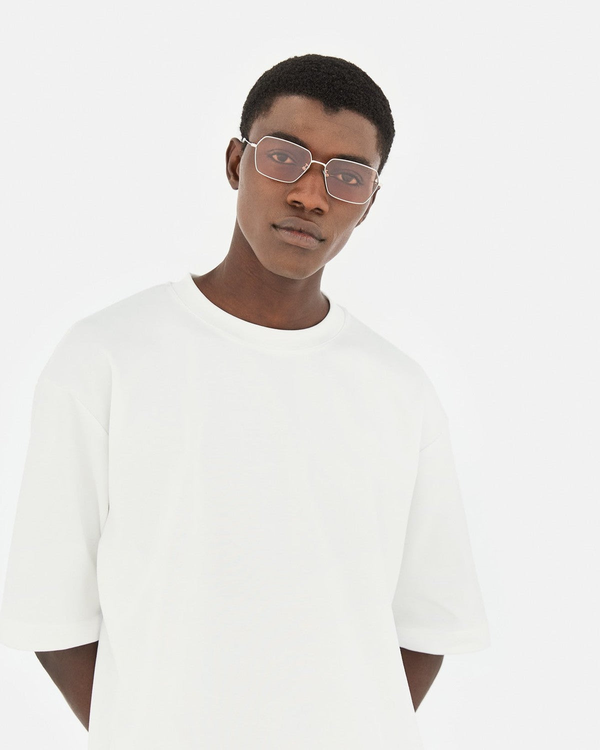 Model wearing RETROSUPERFUTURE Balarm Nebbia Rosa sunglasses indoors.