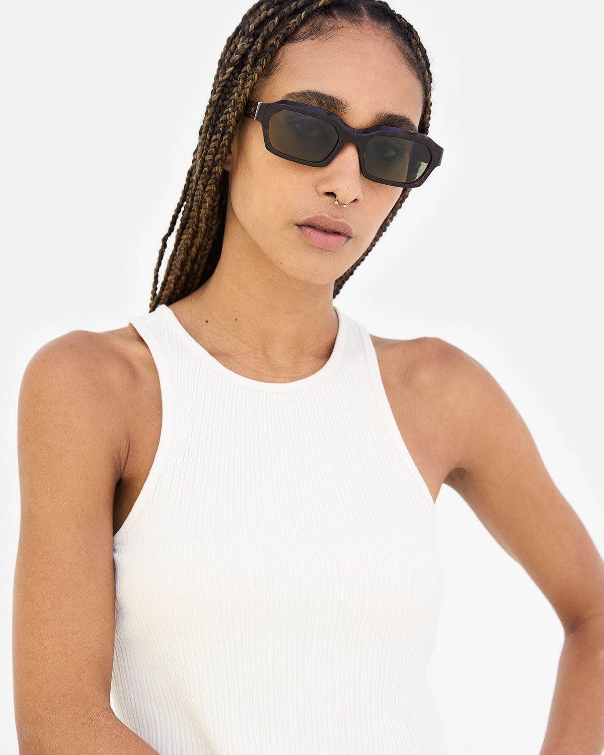 Model wearing RETROSUPERFUTURE Boletus 3627 sunglasses with braids and white tank top, tilting head.