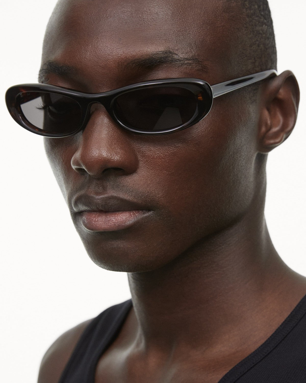 Close-up of model wearing CHIMI Bow Tortoise Green sunglasses showing the tortoise frame detail.