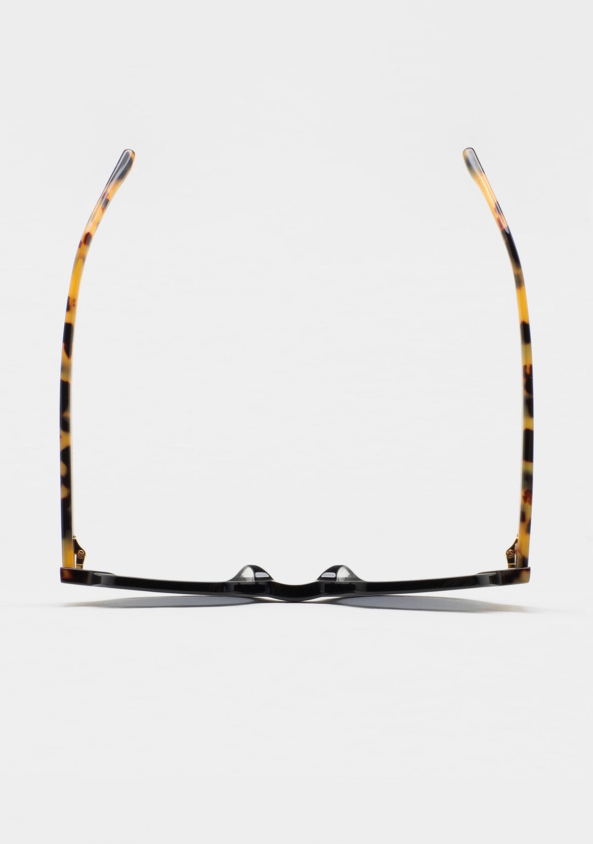 Top-down view of KALEOS Cabana 01 sunglasses showing the tortoiseshell patterned temples and black front.