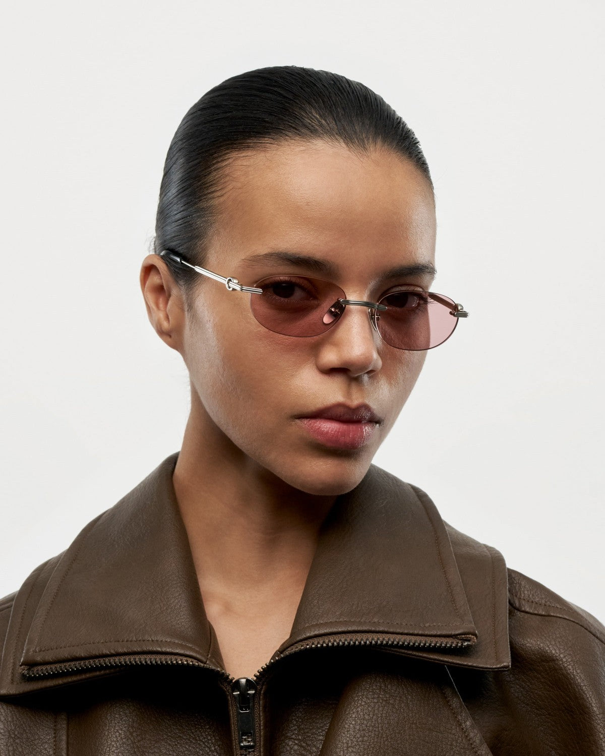 Model wearing CHIMI Cadenza Oval Pink Low sunglasses, angled view.
