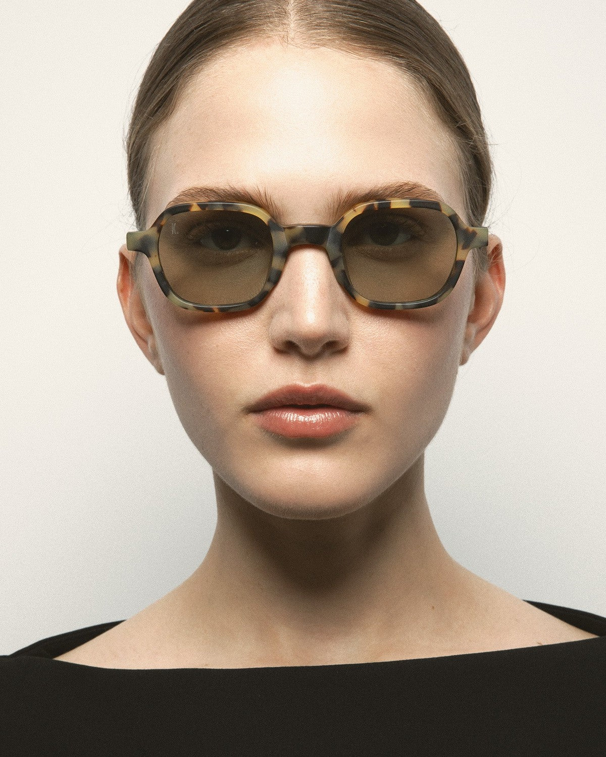 Model wearing KALEOS Castillo Spotted Havana Matte Green Photochromic sunglasses, front view.