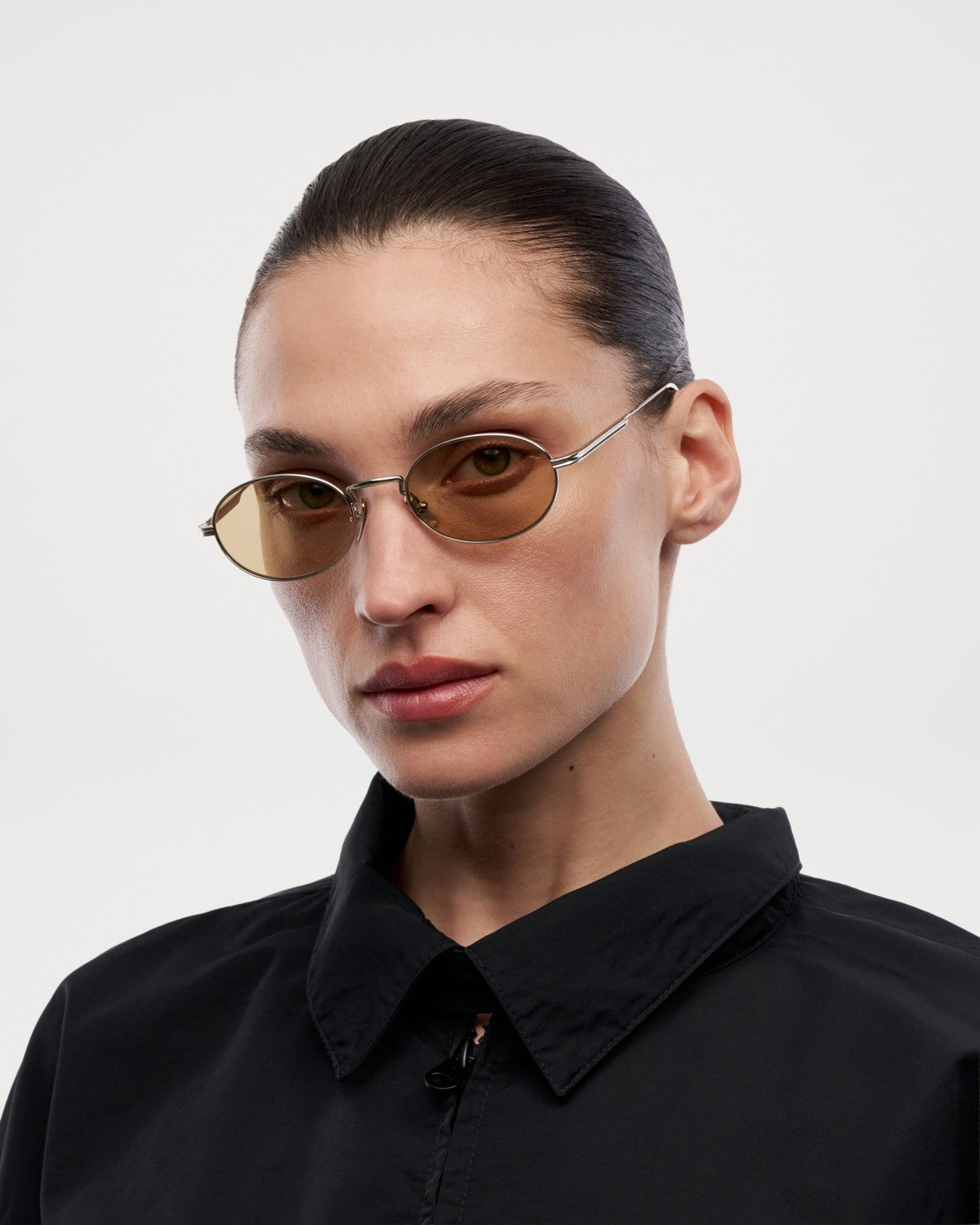 Model wearing CHIMI CC Titan Oval Silver sunglasses from the side.