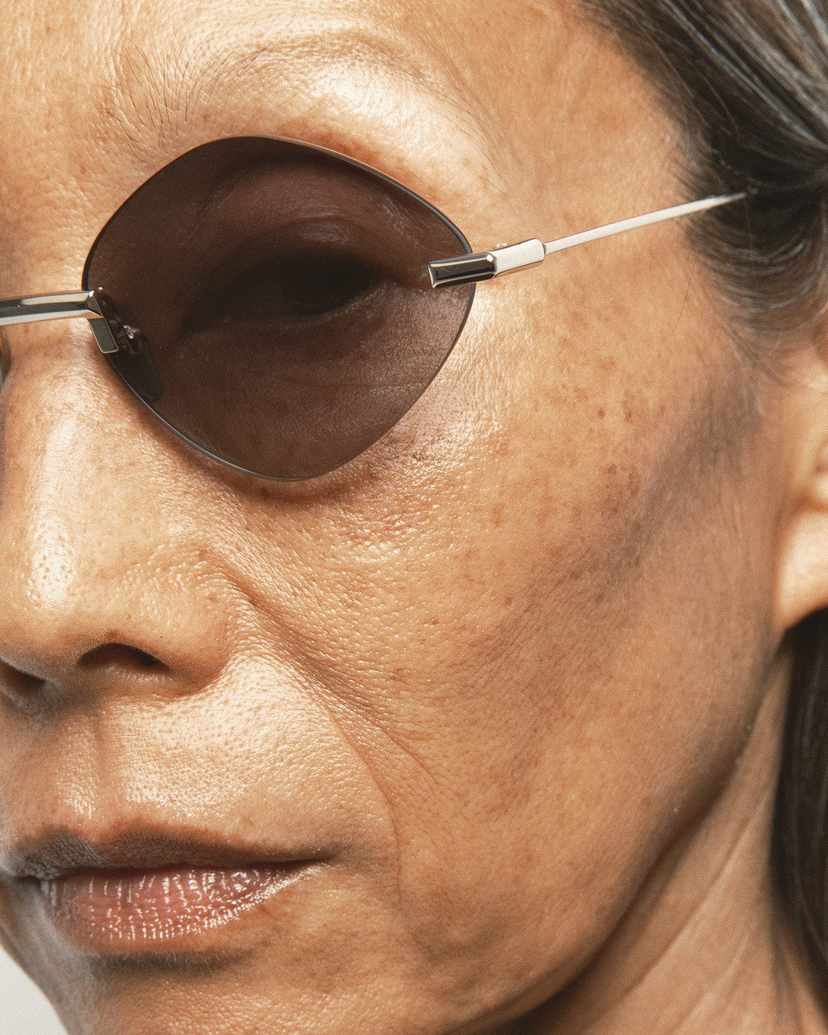 Close-up of the rimless lens and metal bridge on KALEOS Cepeda Gold Black Gradient sunglasses.