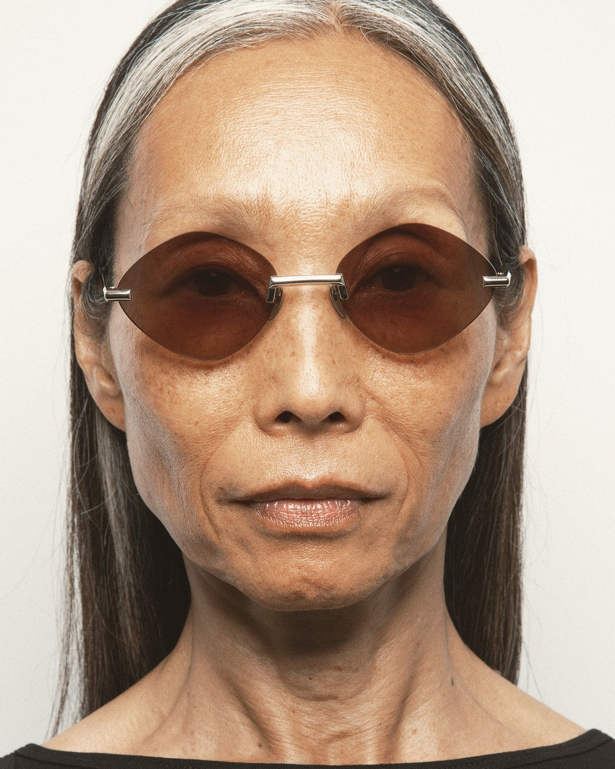 Model wearing KALEOS Cepeda Gold Brown Degrade sunglasses, front view.