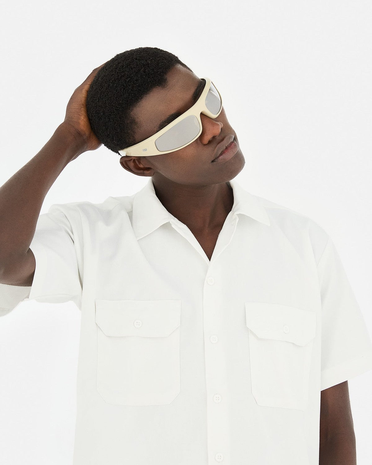 Model wearing RETROSUPERFUTURE Cerchietto Cremoso sunglasses with hand to head.