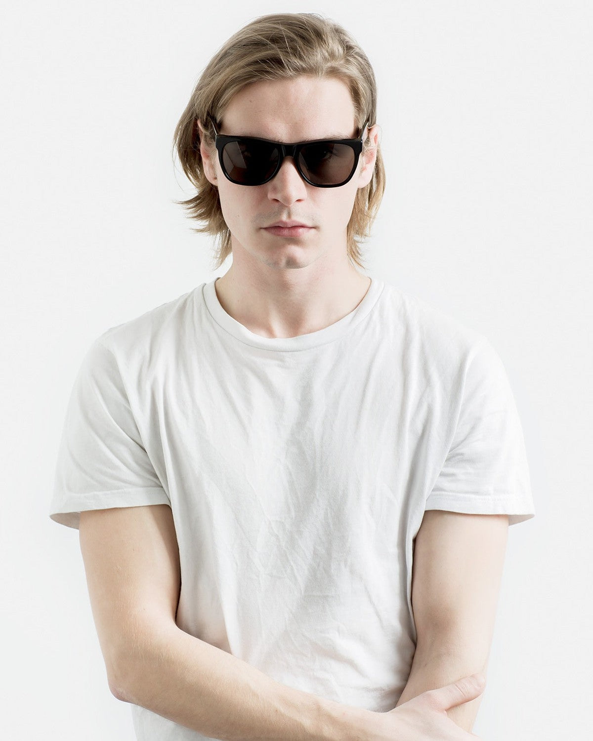 Model wearing RETROSUPERFUTURE Classic Black sunglasses indoors.
