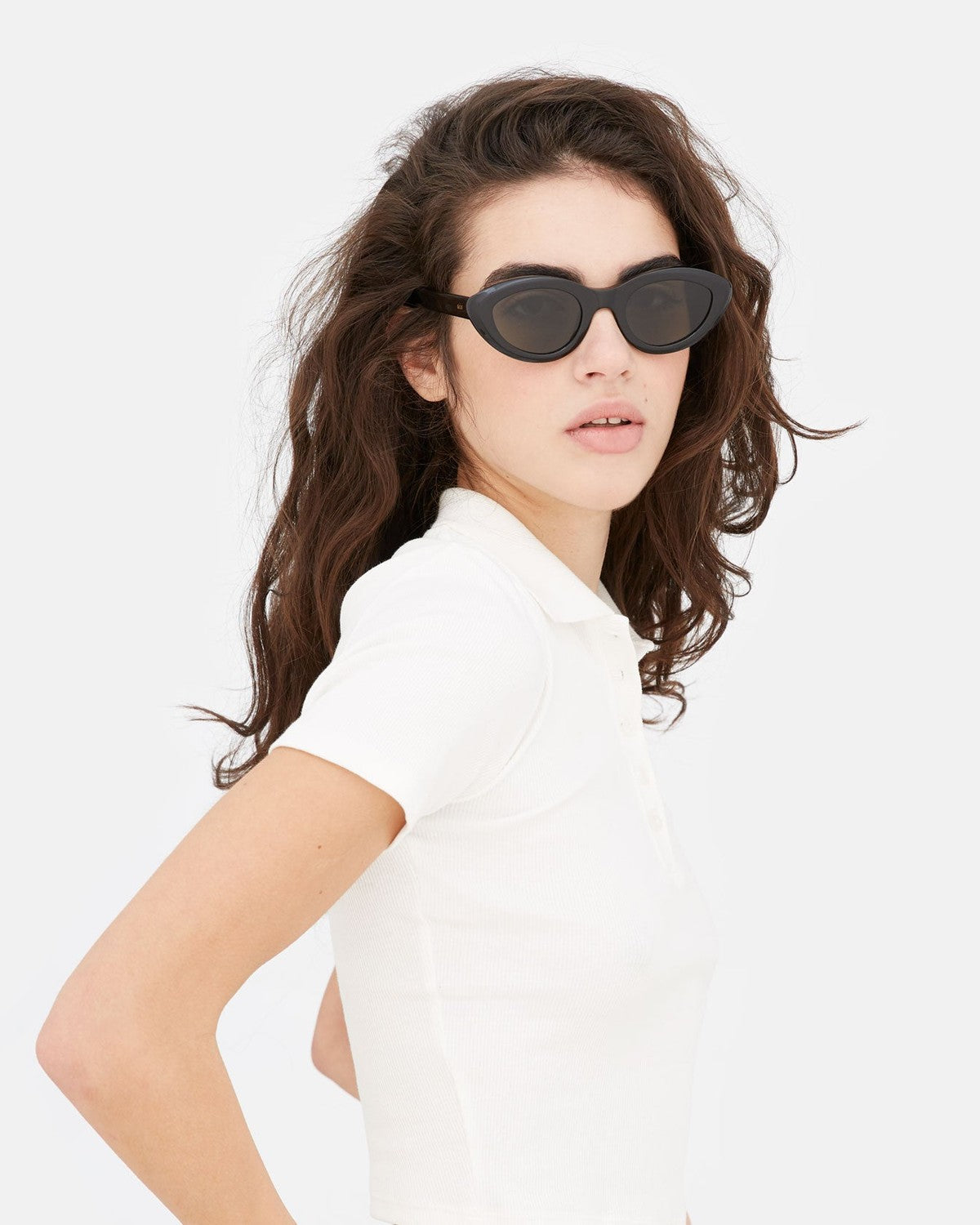 Model wearing RETROSUPERFUTURE Cocca Black sunglasses in a white shirt.