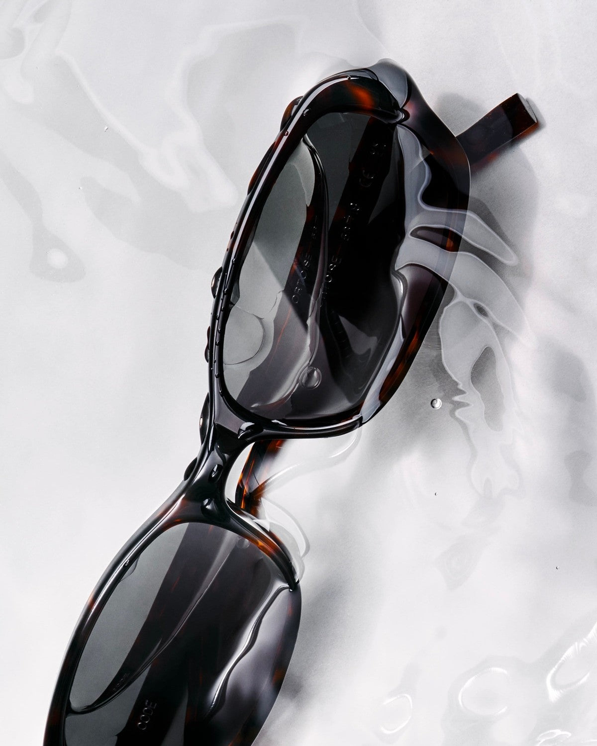 Close-up detail of CHIMI Code Tortoise sunglasses on reflective surface.