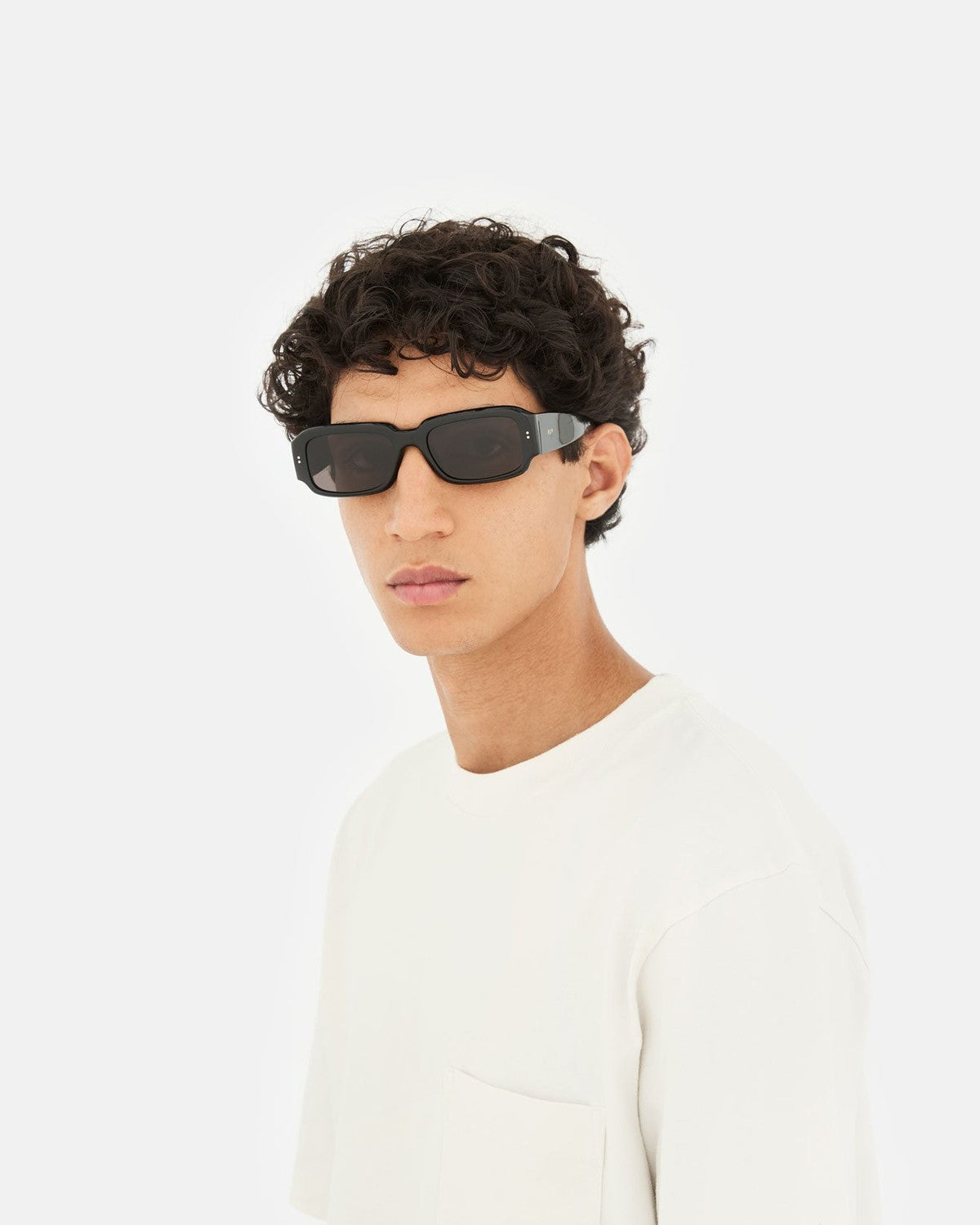 Model wearing RETROSUPERFUTURE Etrusco Black sunglasses indoors.