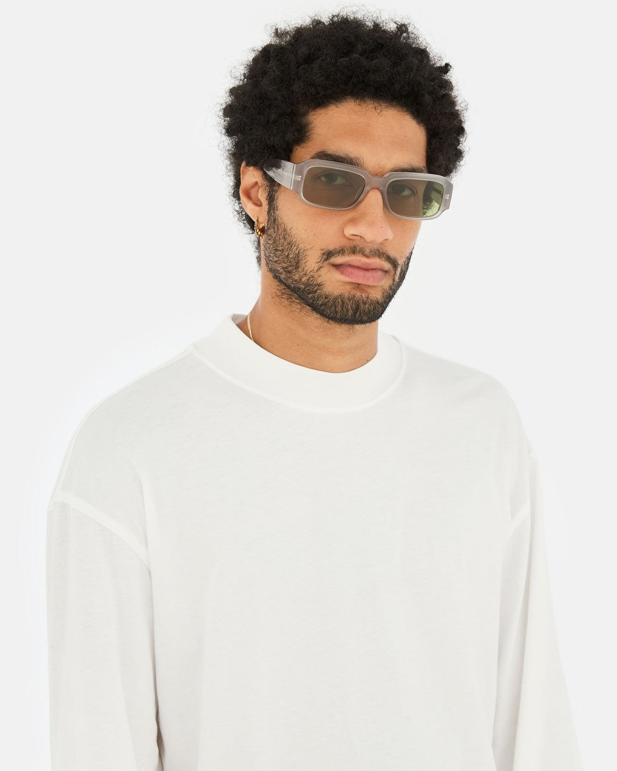 Model wearing RETROSUPERFUTURE Etrusco Light Grey sunglasses in white sweater.