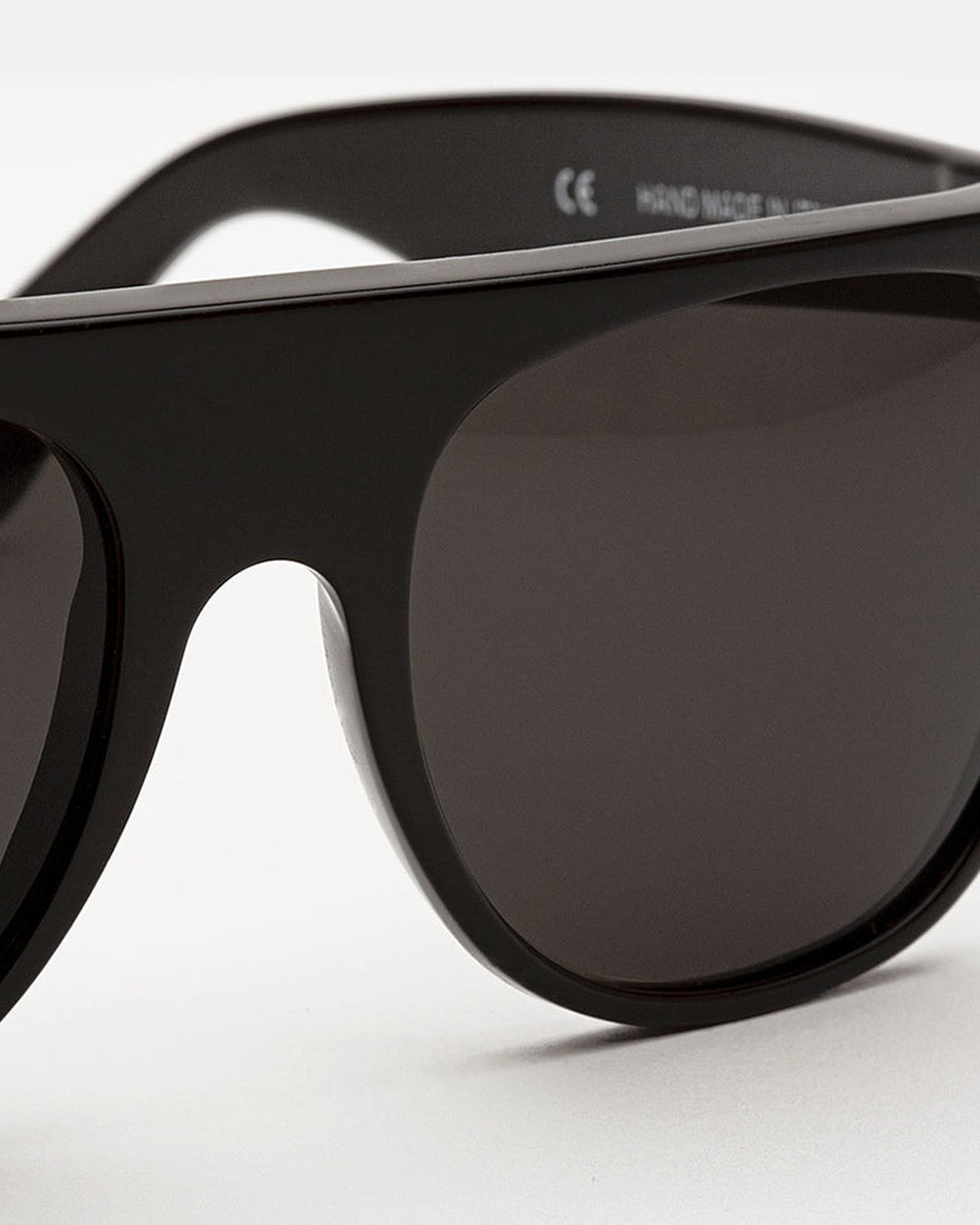 Close-up of the bridge and lens construction on RETROSUPERFUTURE Flat Top Black sunglasses.