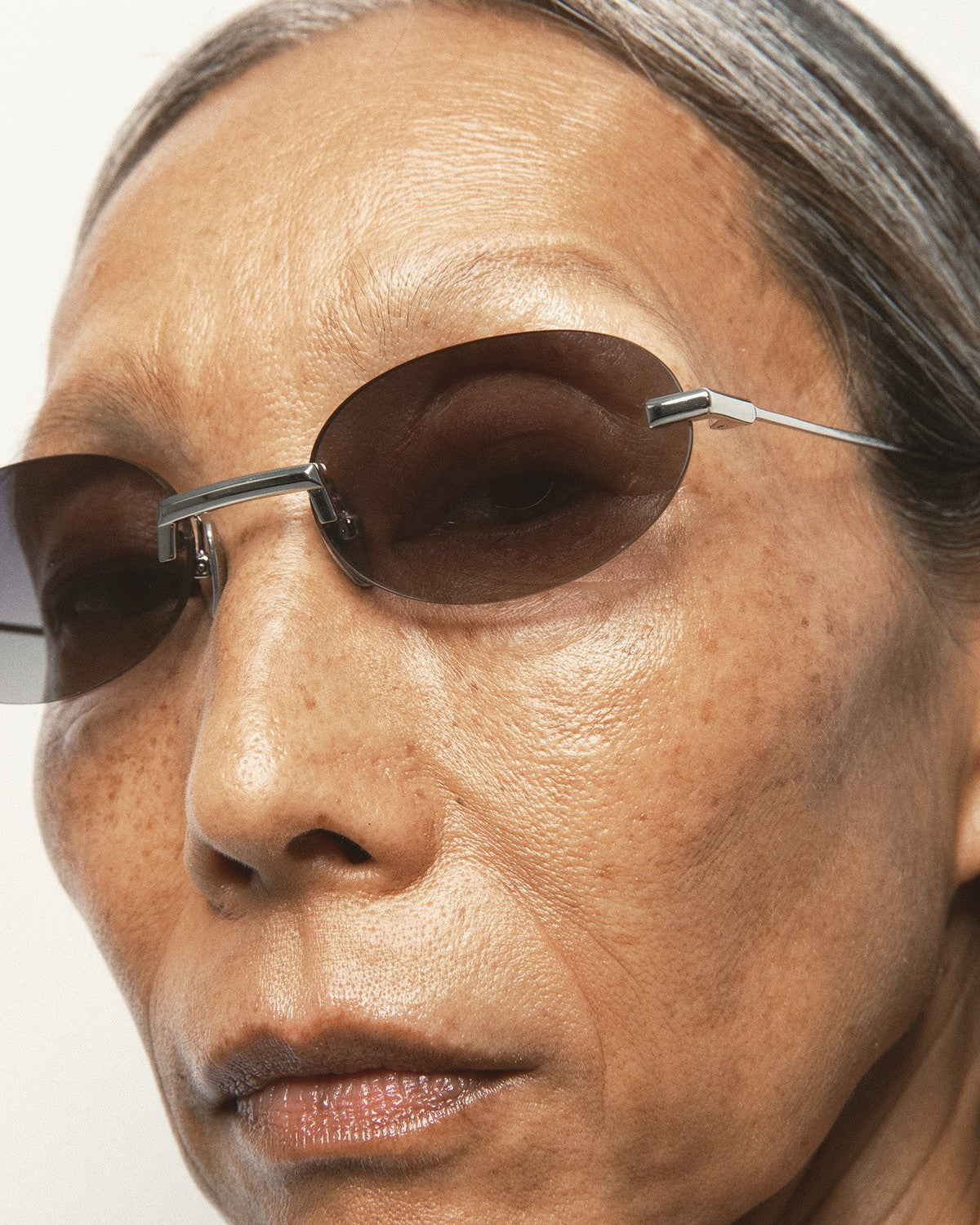 Close-up of model wearing KALEOS Fuentes Silver Black Gradient sunglasses.