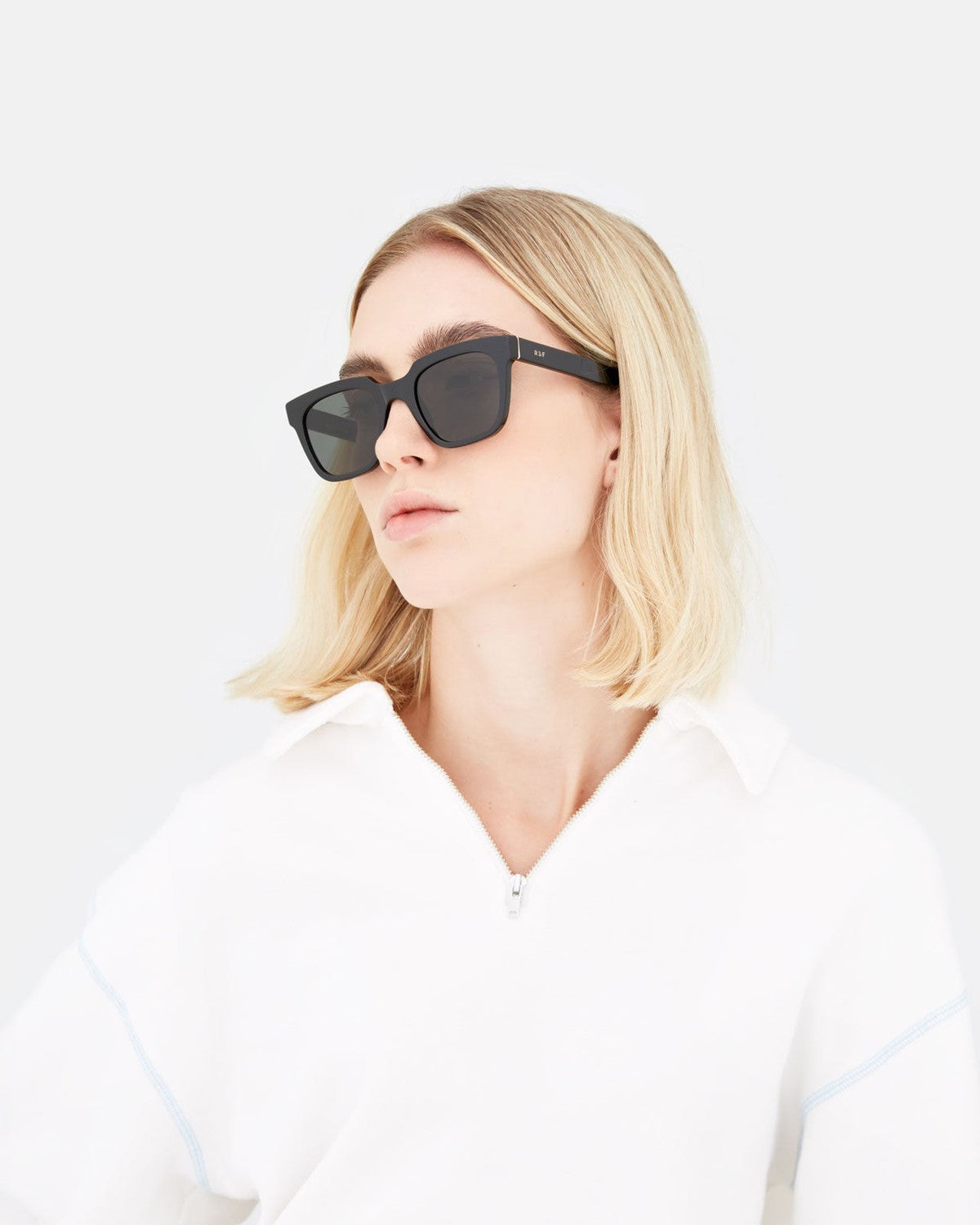 Model wearing RETROSUPERFUTURE Giusto Black sunglasses, side view.