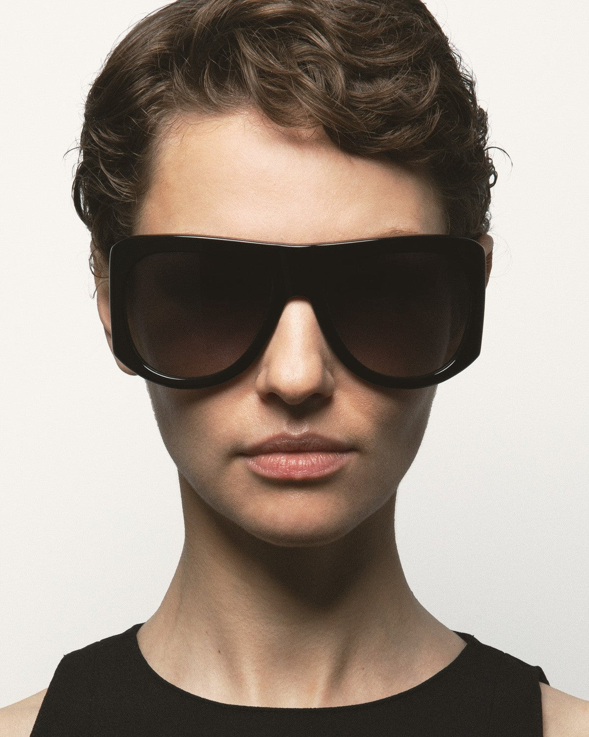 Model wearing KALEOS Haworth Black Black sunglasses, front view.
