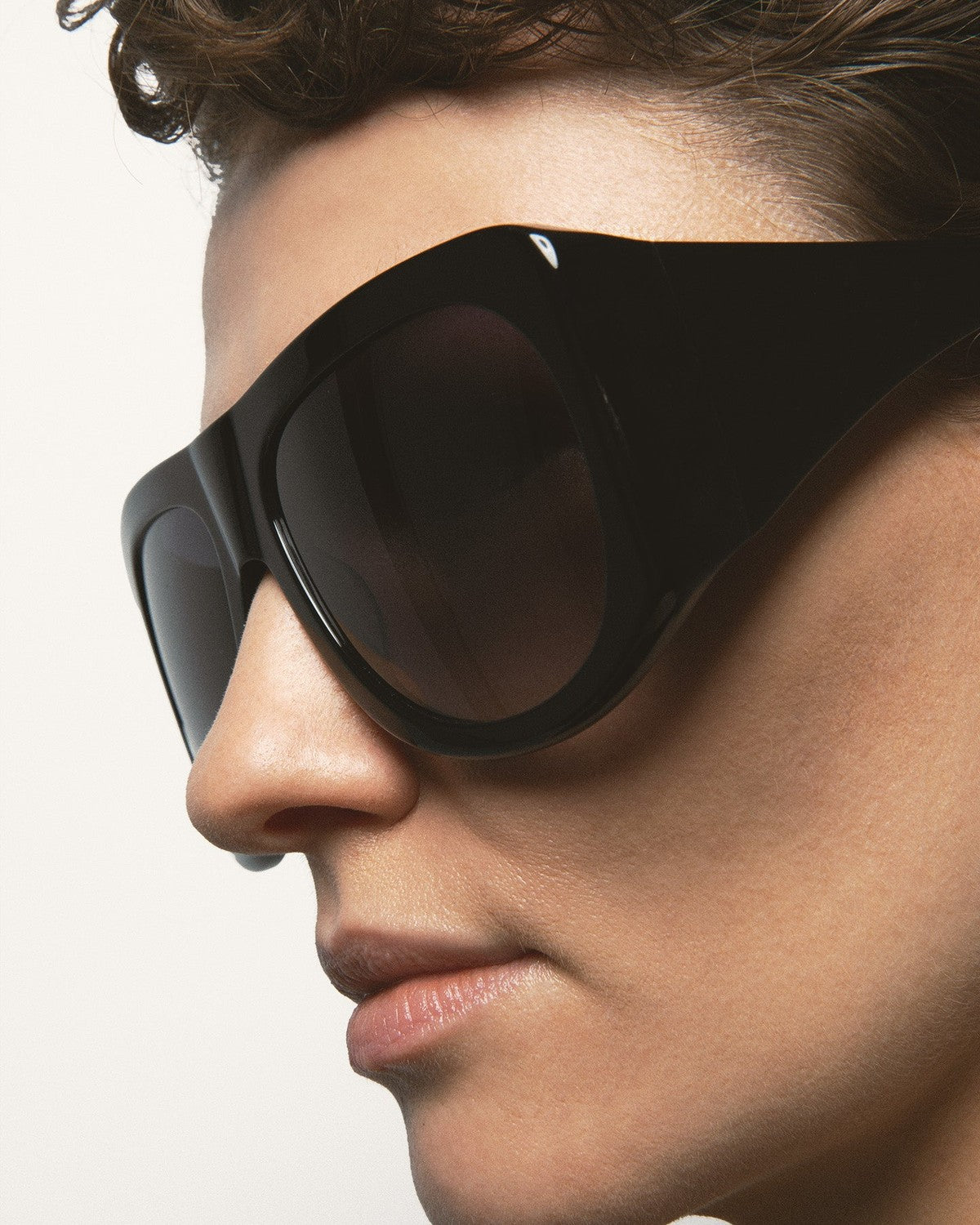 Angled close-up of model wearing KALEOS Haworth Black Black sunglasses.