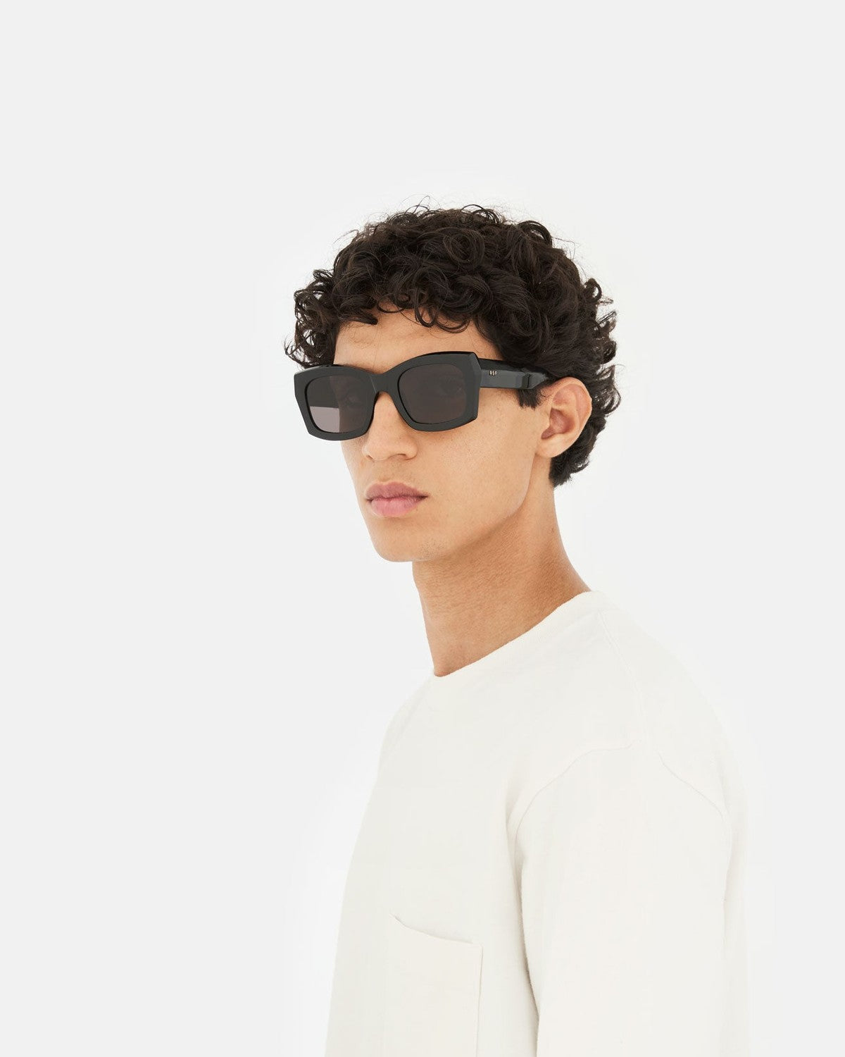 Side profile of model wearing RETROSUPERFUTURE Komori Black sunglasses.