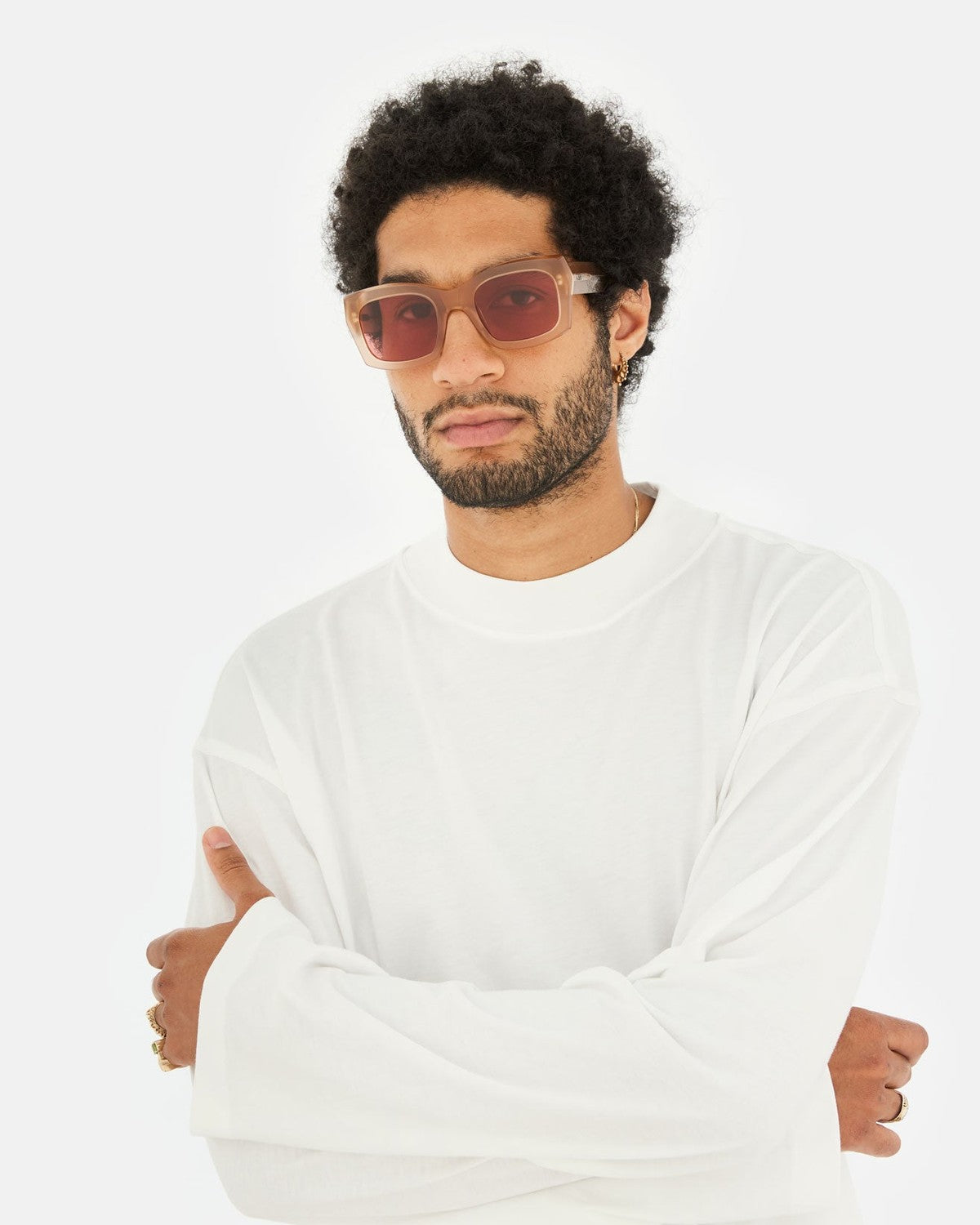 Model wearing RETROSUPERFUTURE Komori Light Brown sunglasses with white long-sleeve shirt and arms crossed.