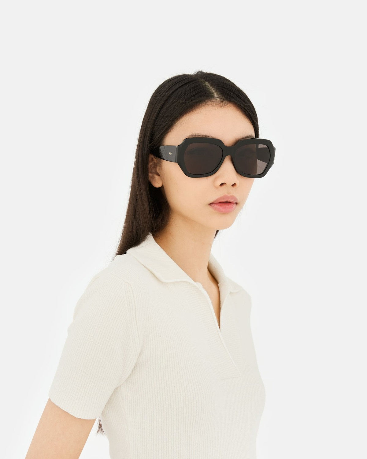 Model wearing RETROSUPERFUTURE Nala Black sunglasses, side view.