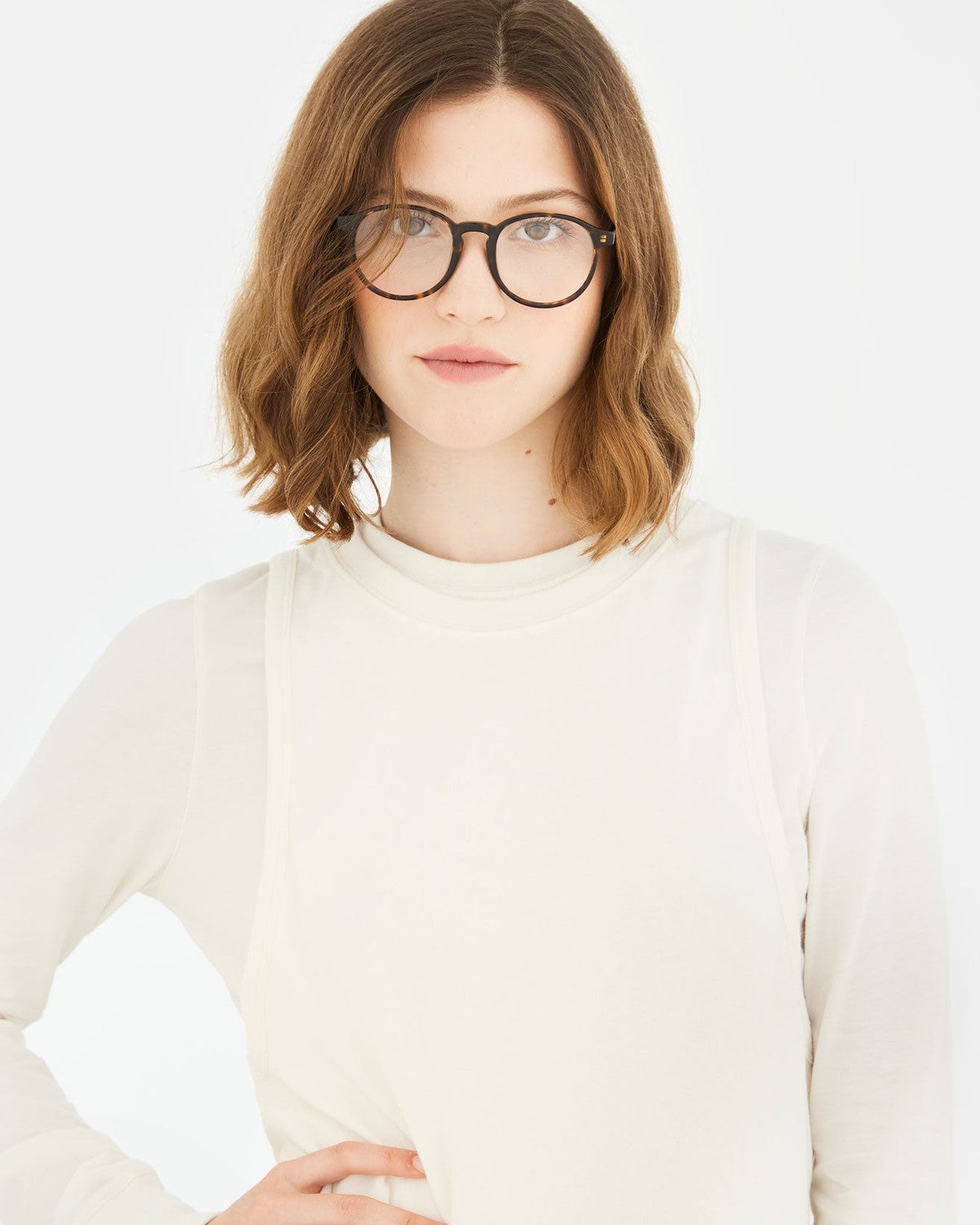 Model wearing RETROSUPERFUTURE Numero 01 3627 sunglasses with wavy hair and cream top.
