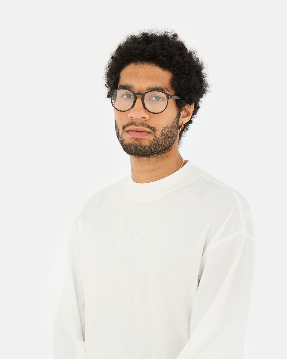 Model wearing RETROSUPERFUTURE Numero 01 3627 sunglasses in white long-sleeve shirt.
