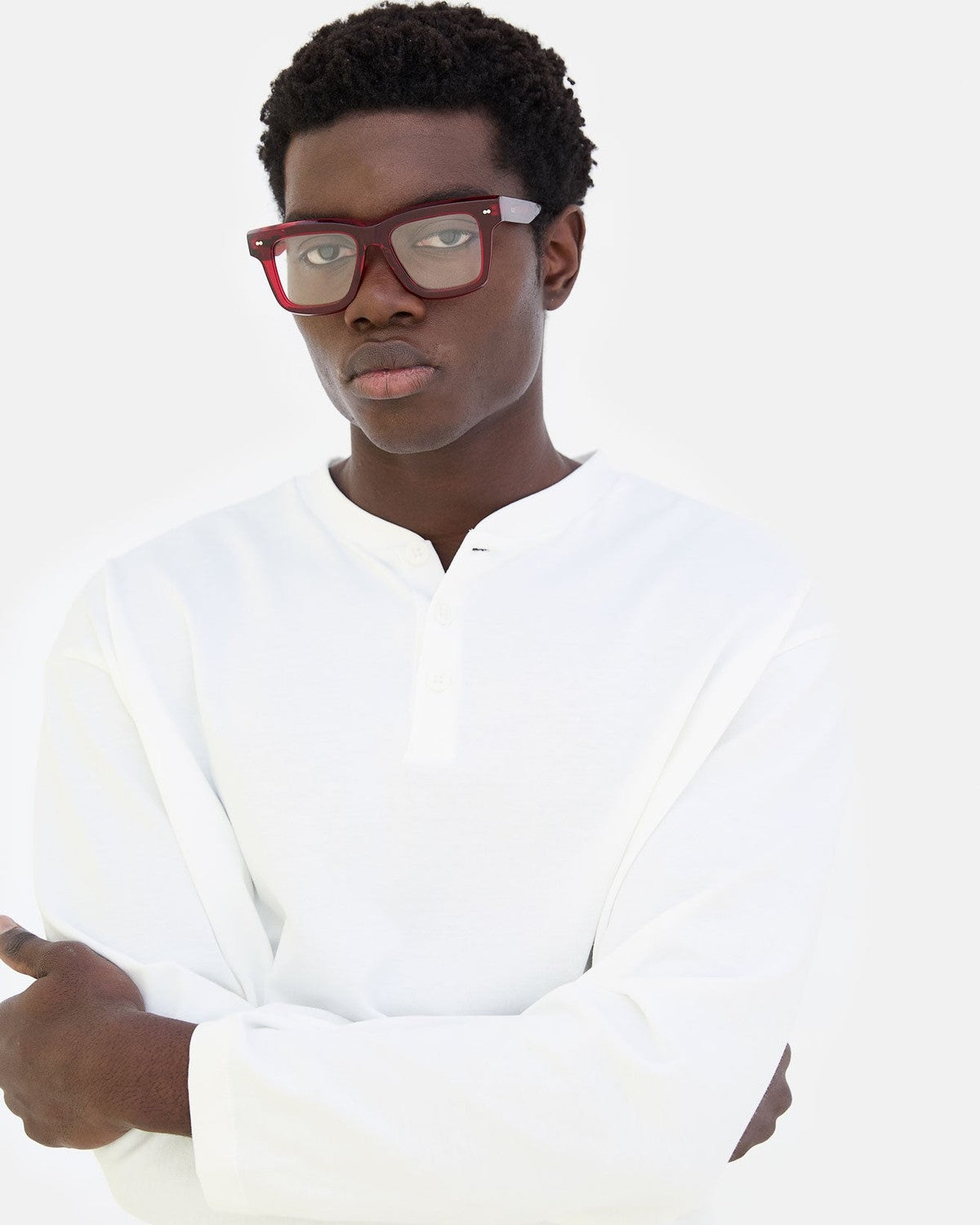 Model wearing RETROSUPERFUTURE Numero 116 Mattone sunglasses with arms crossed in white shirt.