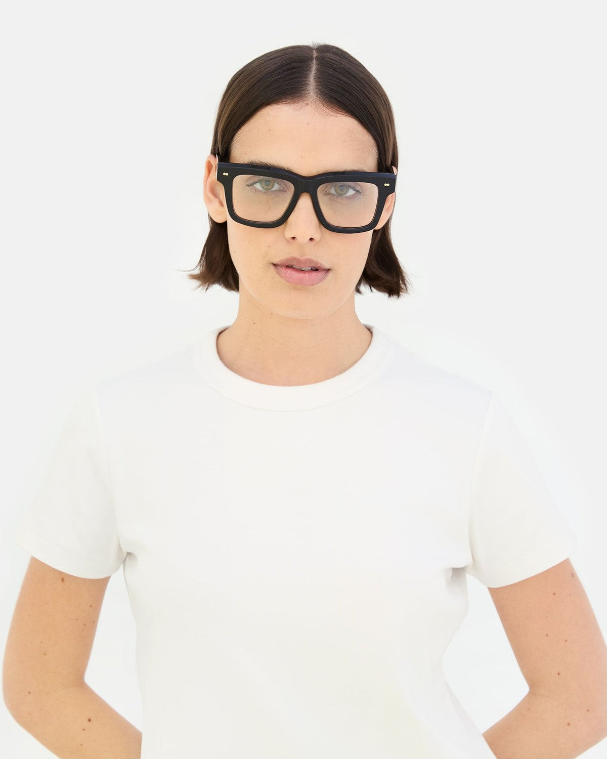 Model wearing RETROSUPERFUTURE Numero 116 Nero sunglasses with white t-shirt.