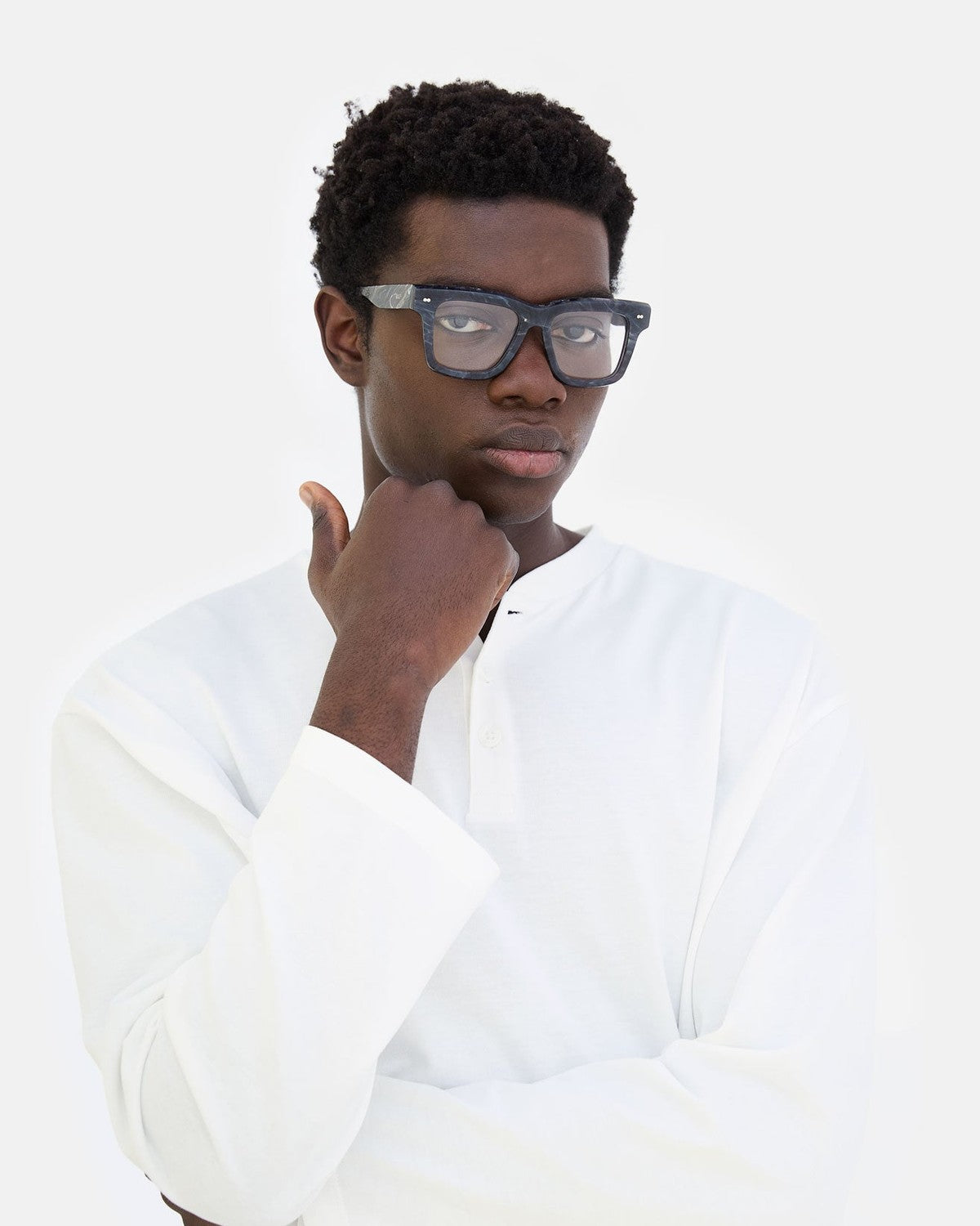 Model wearing RETROSUPERFUTURE Numero 116 Marmo Nero sunglasses with hand to chin.