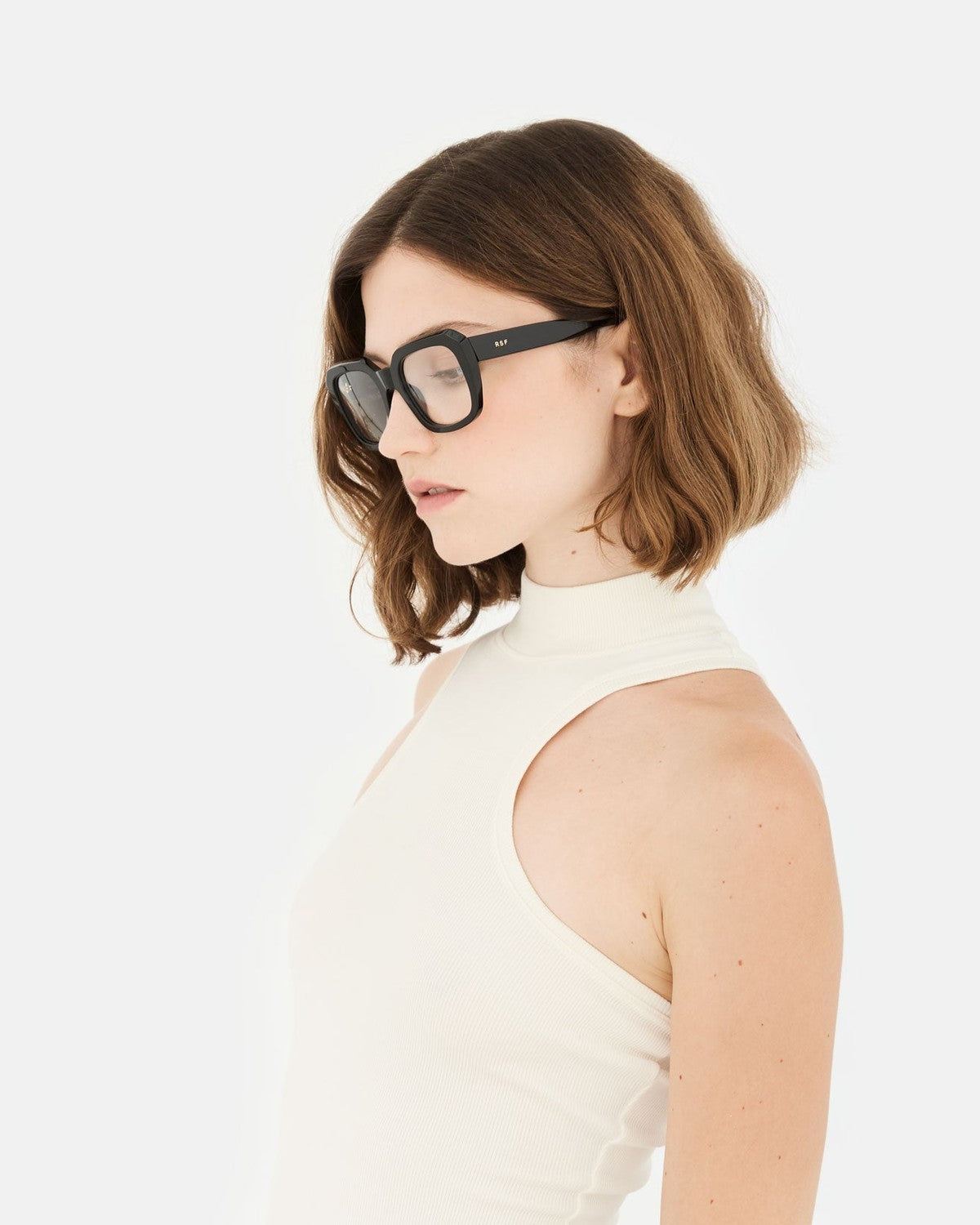 Model wearing RETROSUPERFUTURE Numero 125 Black sunglasses in profile.