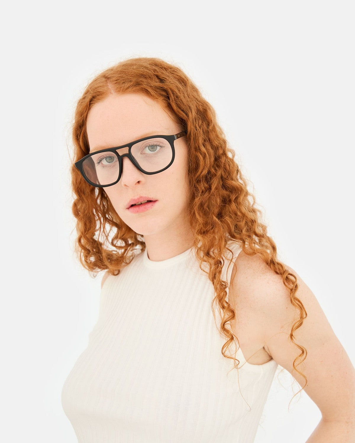 Model wearing RETROSUPERFUTURE Numero 127 Black sunglasses with a white sleeveless top, frontal view.