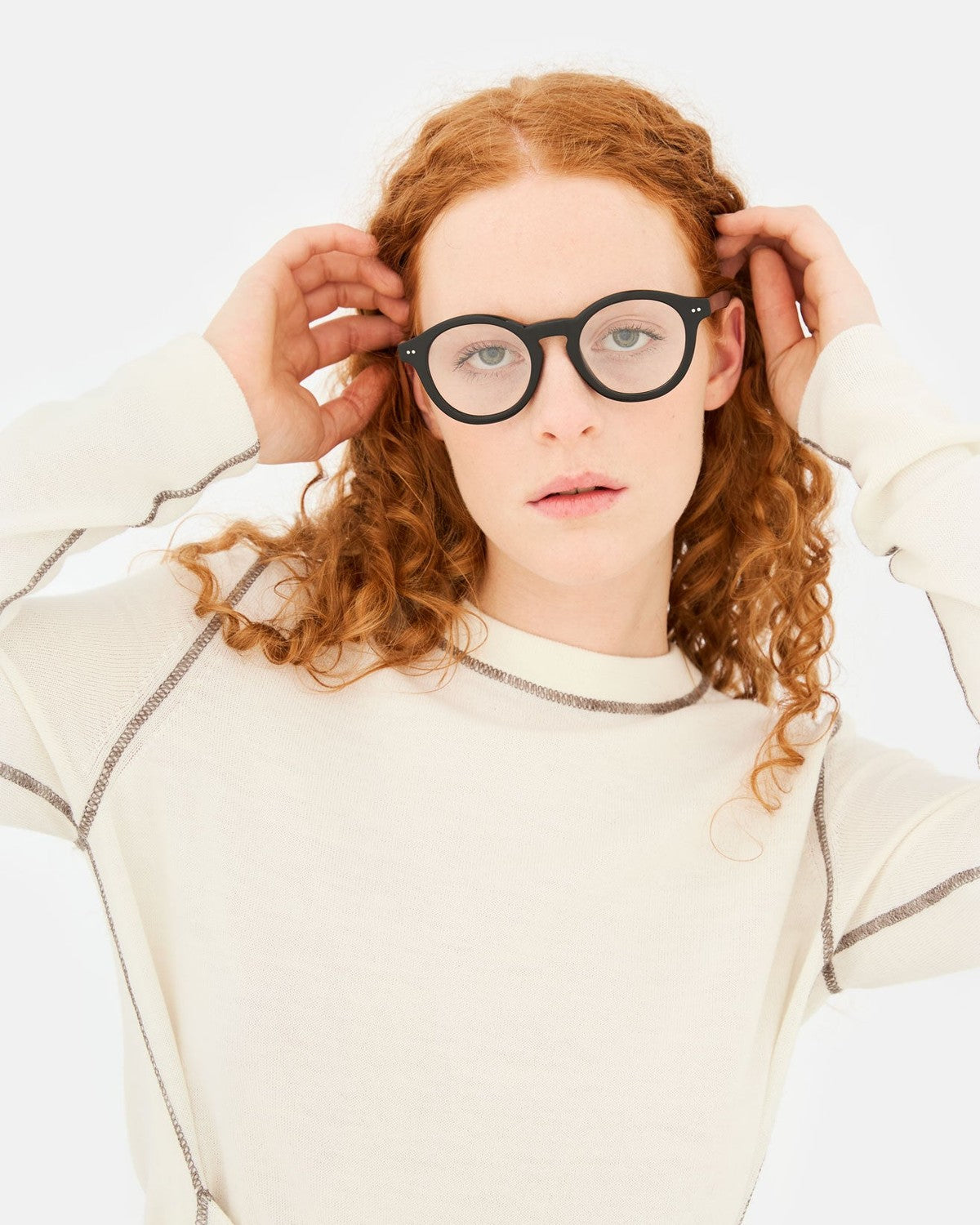 Model adjusting RETROSUPERFUTURE Numero 129 Black sunglasses.