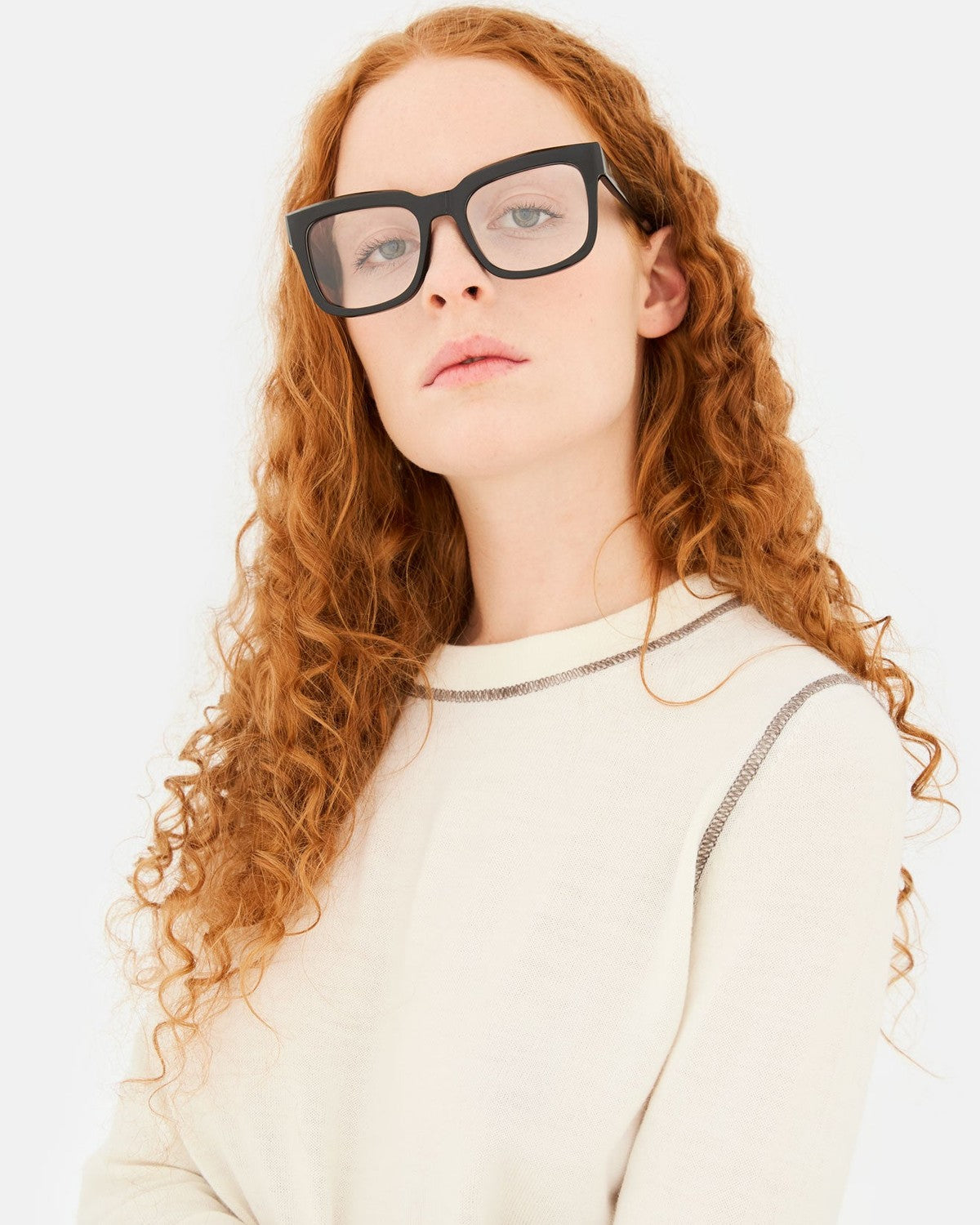 Model wearing RETROSUPERFUTURE Numero 136 Black sunglasses, angled upward.