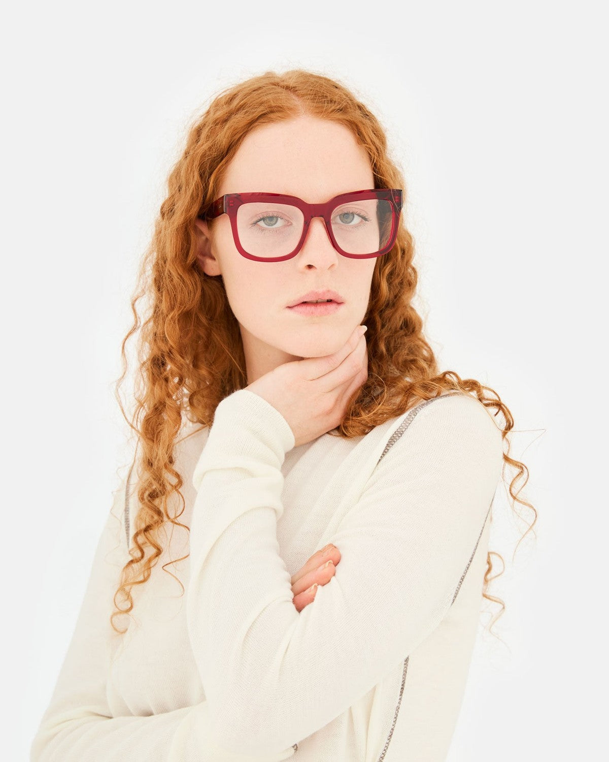 Model wearing RETROSUPERFUTURE Numero 136 Rossissimo sunglasses with hand near chin.