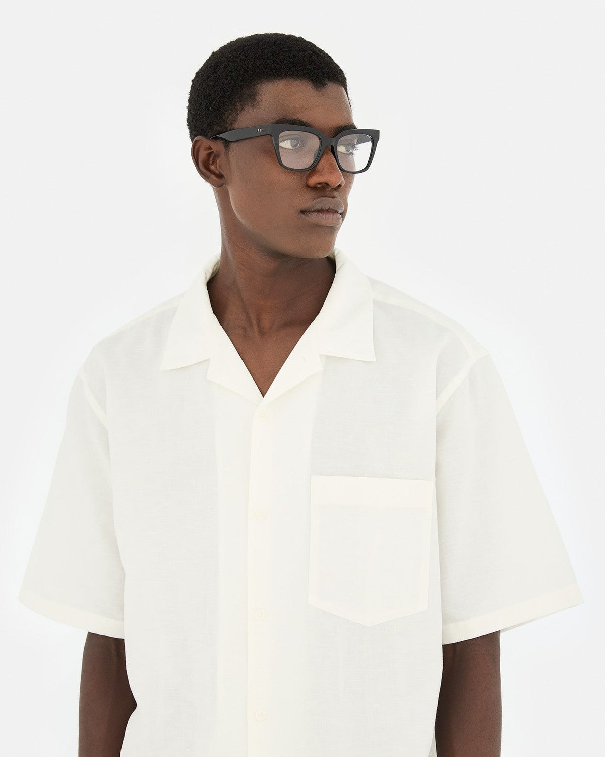 Model wearing RETROSUPERFUTURE Numero 143 Nero sunglasses with a white shirt.