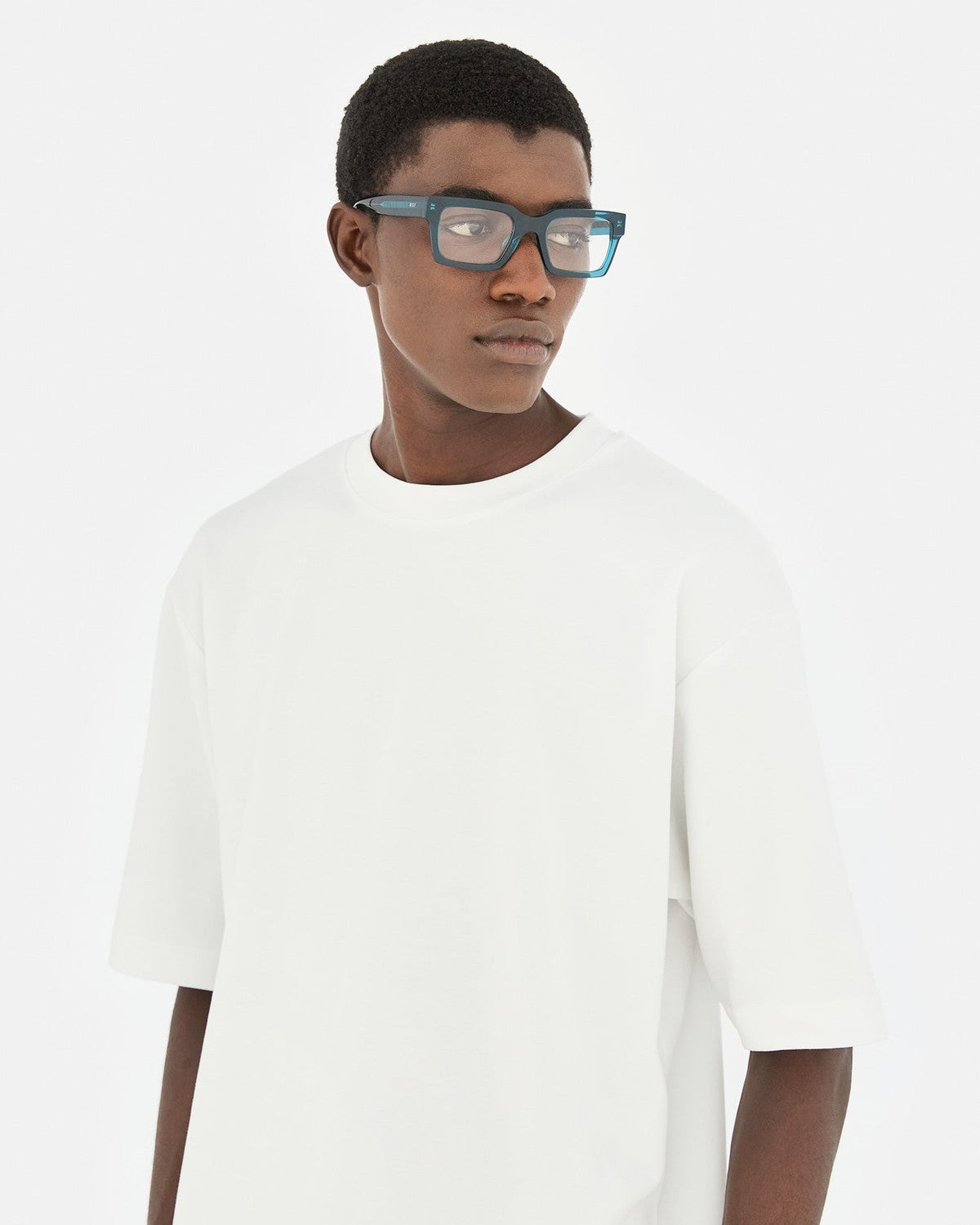 Model wearing RETROSUPERFUTURE Numero 144 Teal sunglasses in three-quarter view.