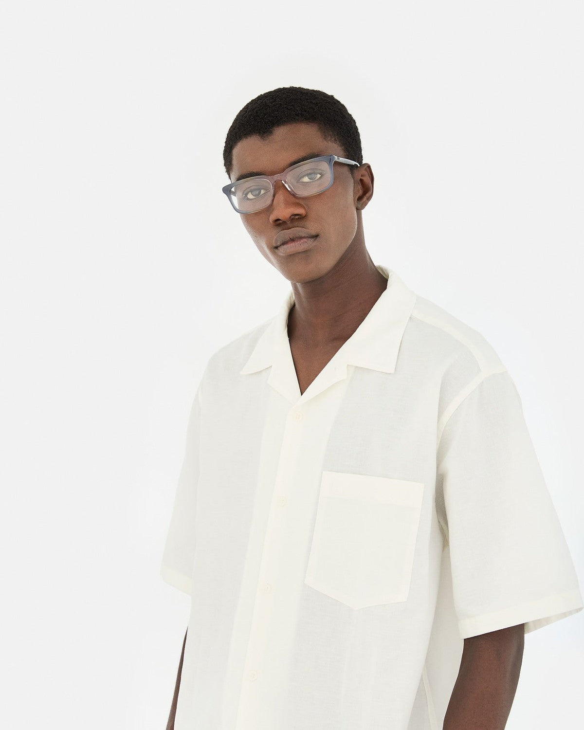 Model in a cream short-sleeved shirt wearing RETROSUPERFUTURE Numero 146 Side Fade sunglasses.