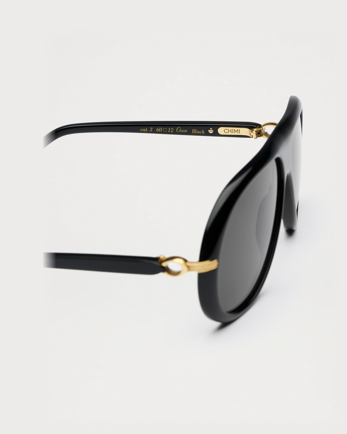 Close-up of the gold-tone hinge and temple branding on CHIMI Oona Black sunglasses.