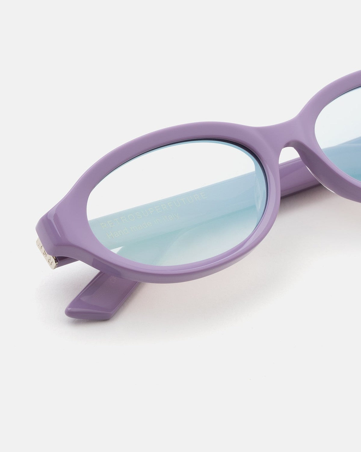Close-up detail of the oval lens and frame of RETROSUPERFUTURE Parola Caramella sunglasses.