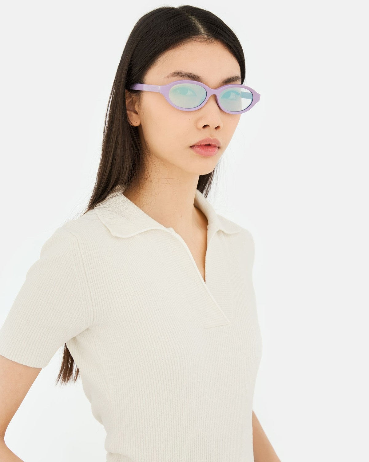 Model wearing RETROSUPERFUTURE Parola Caramella sunglasses with cream polo shirt.