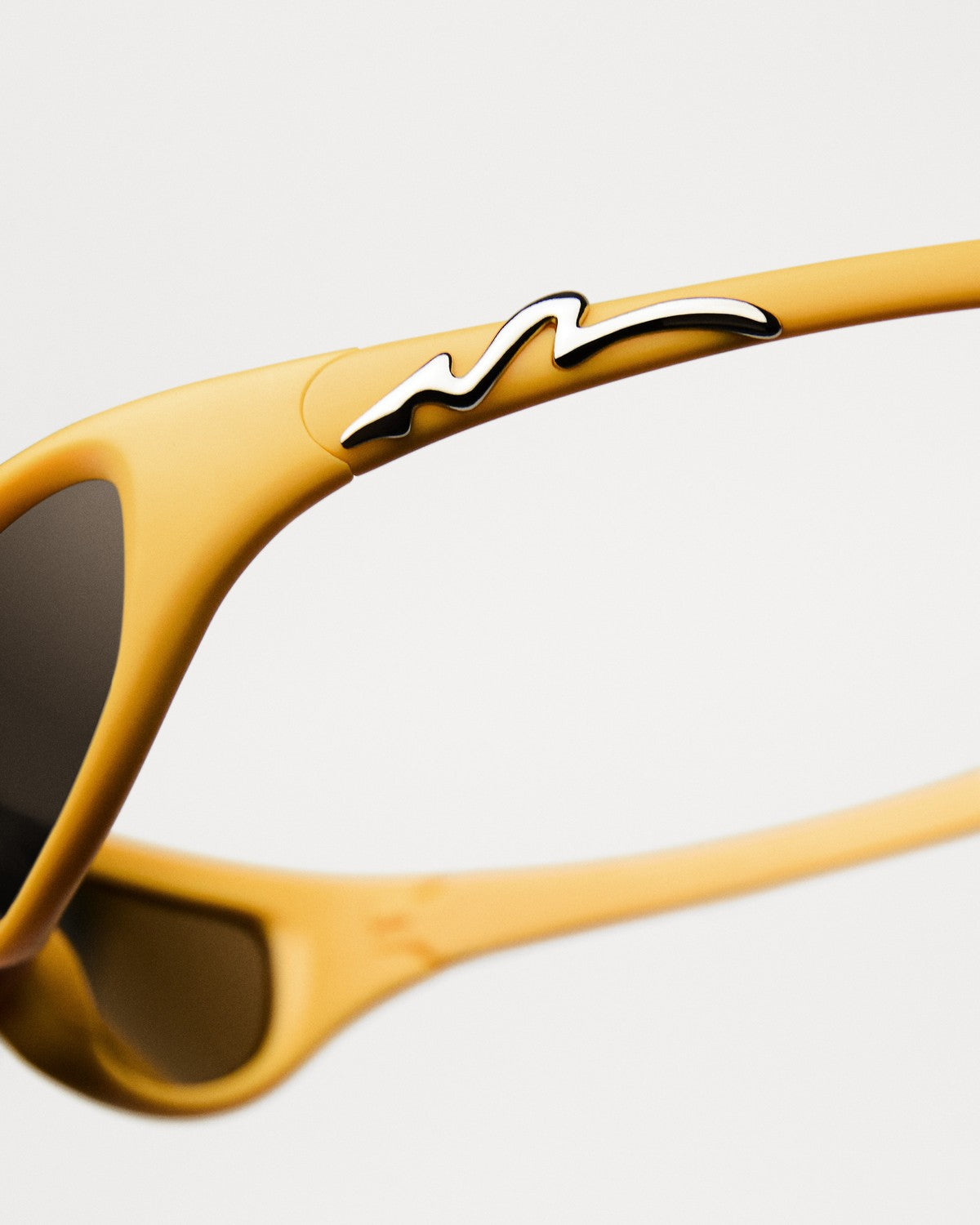 Close-up of the wave-pattern temple detail on CHIMI Pogba Yellow Brown sunglasses.