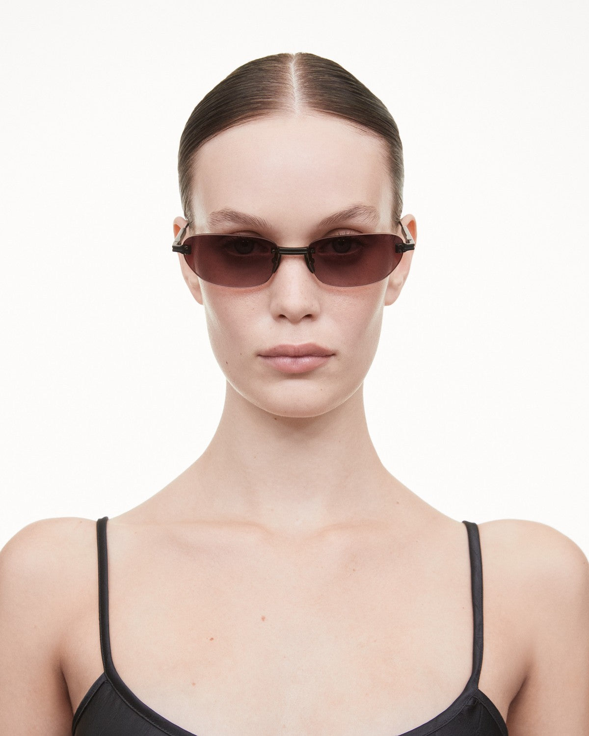 Model wearing CHIMI Rimless Oval Burgundy Gradient Red sunglasses, front view.